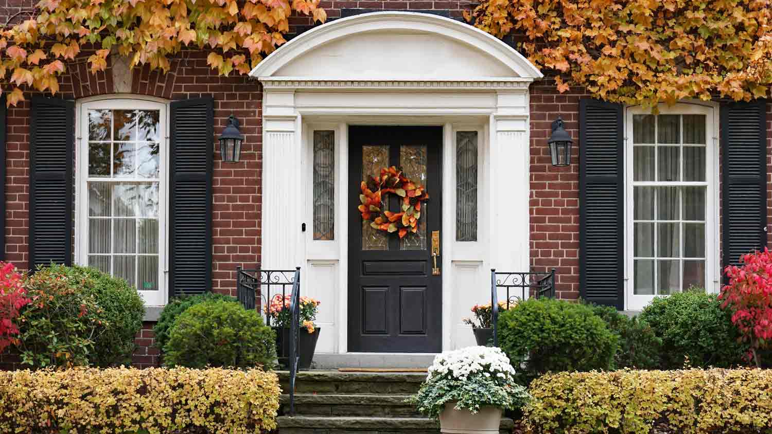 brick house with shrubs along the front in the fall