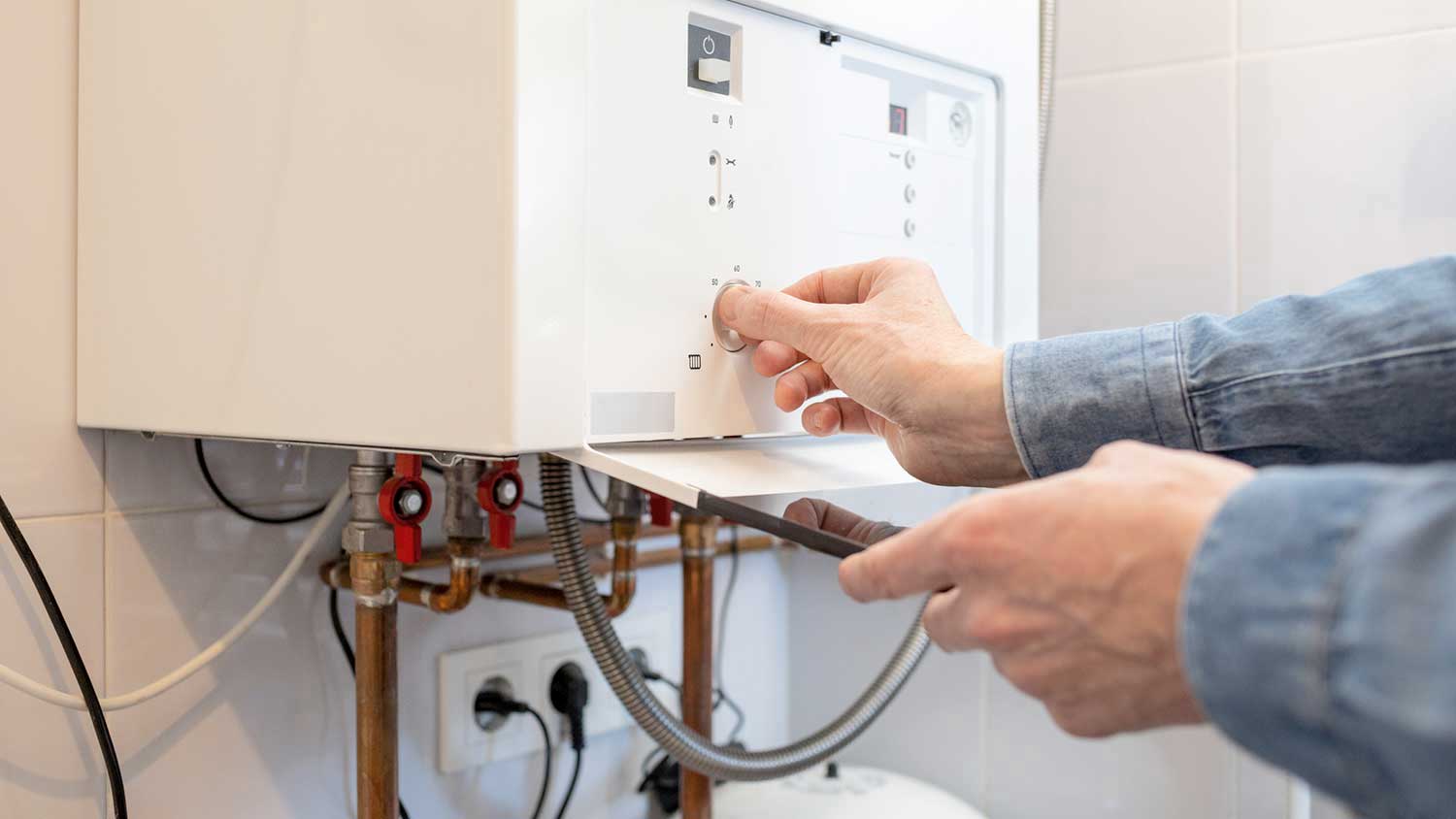 Man lowering water temperature in the water heater