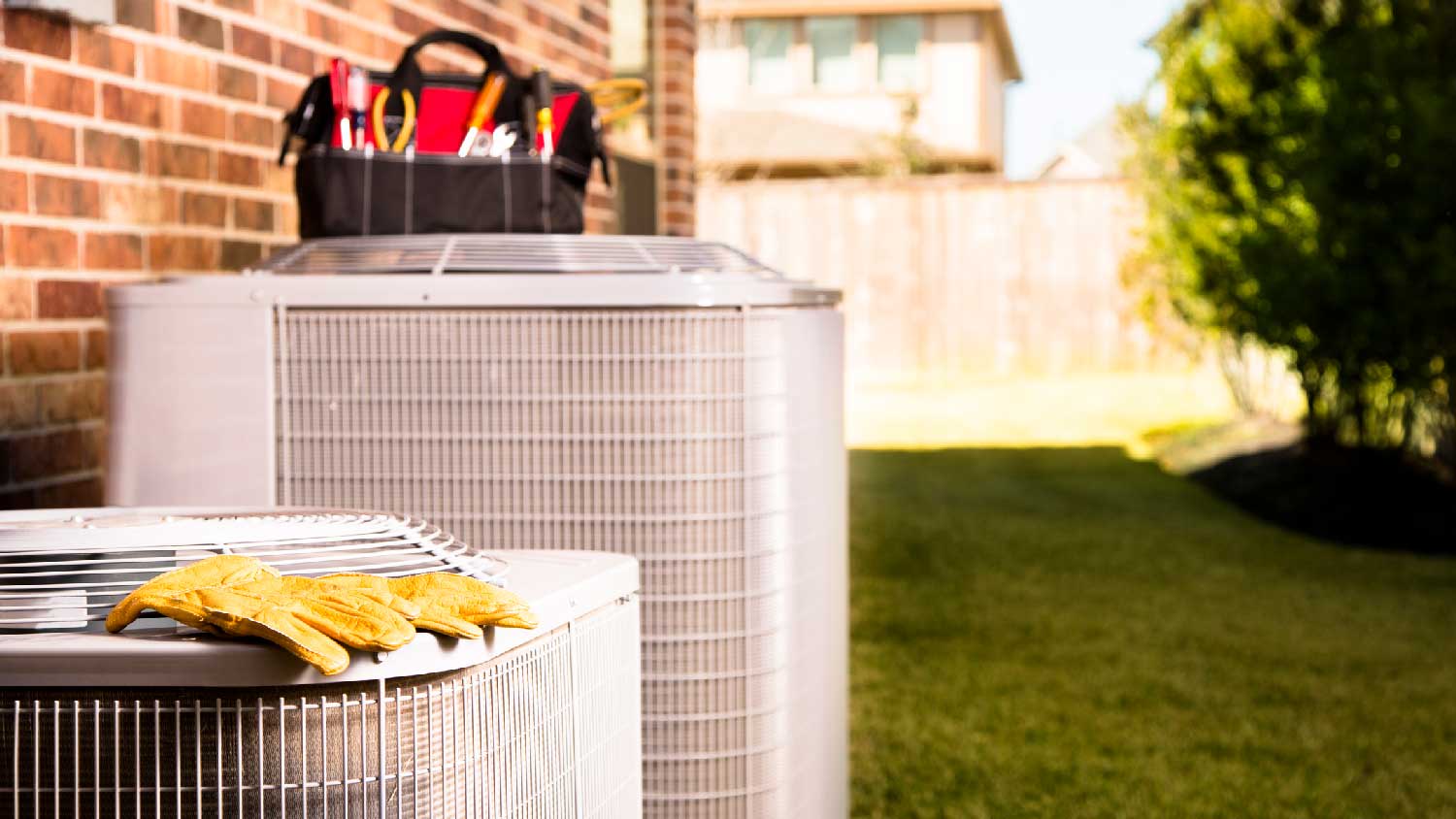 An HVAC in a backyard with tools on it