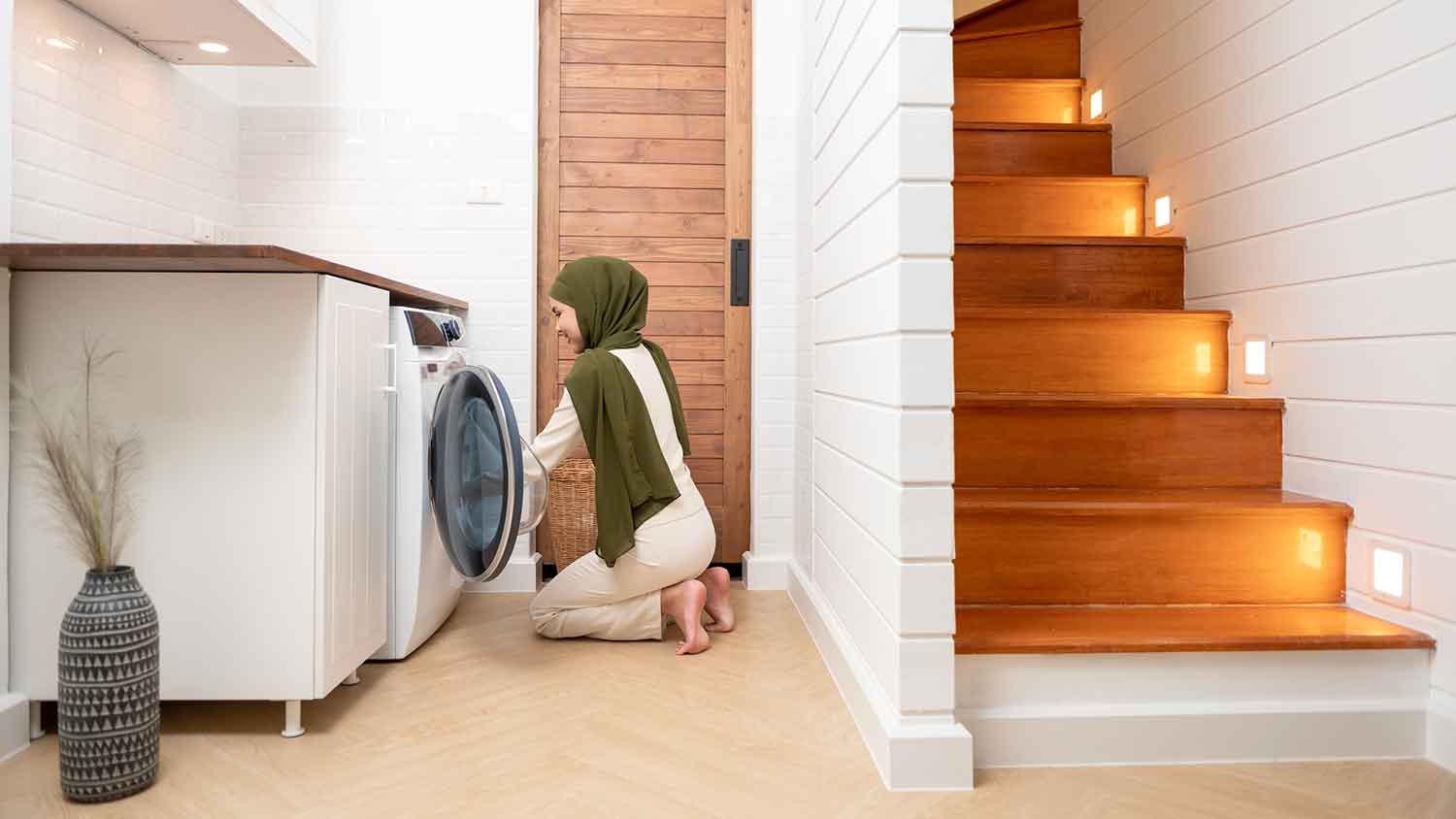 Woman in the laundry room loading washing machine