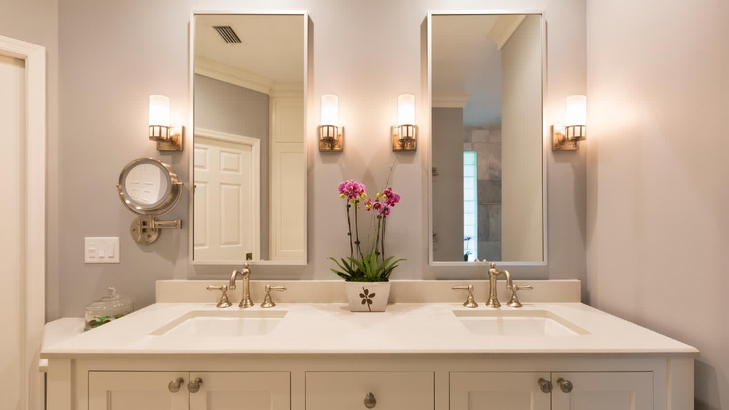 A luxury bathroom with four sconces on the wall