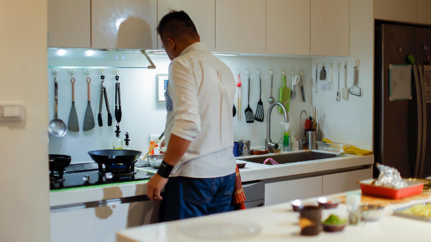 A man cooking in the kitchen with daylight light bulbs
