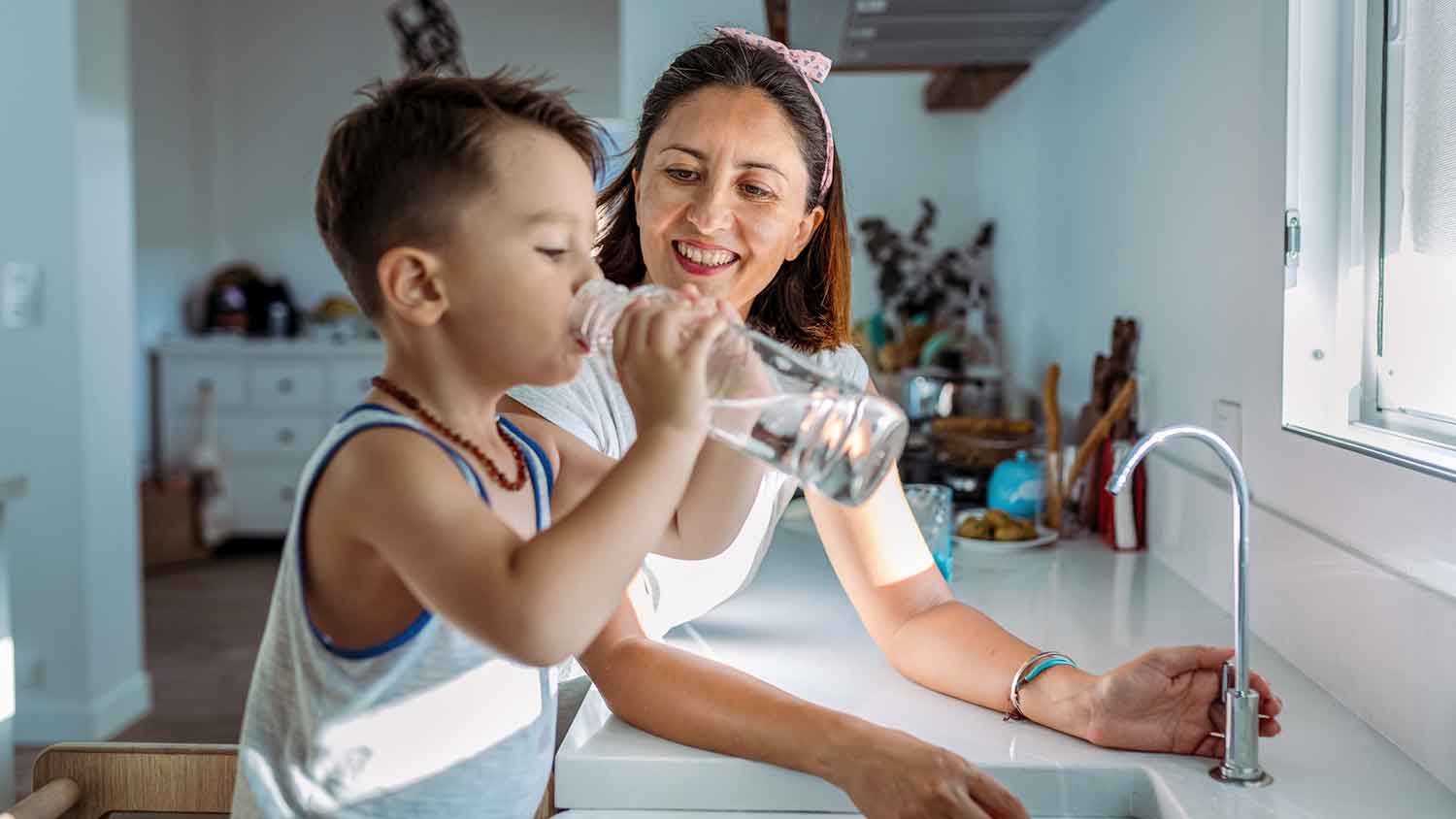 Boy in the kitchen drinking purified water