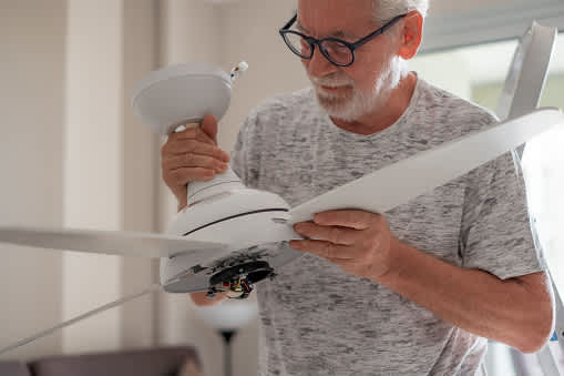 Man holding white ceiling fan