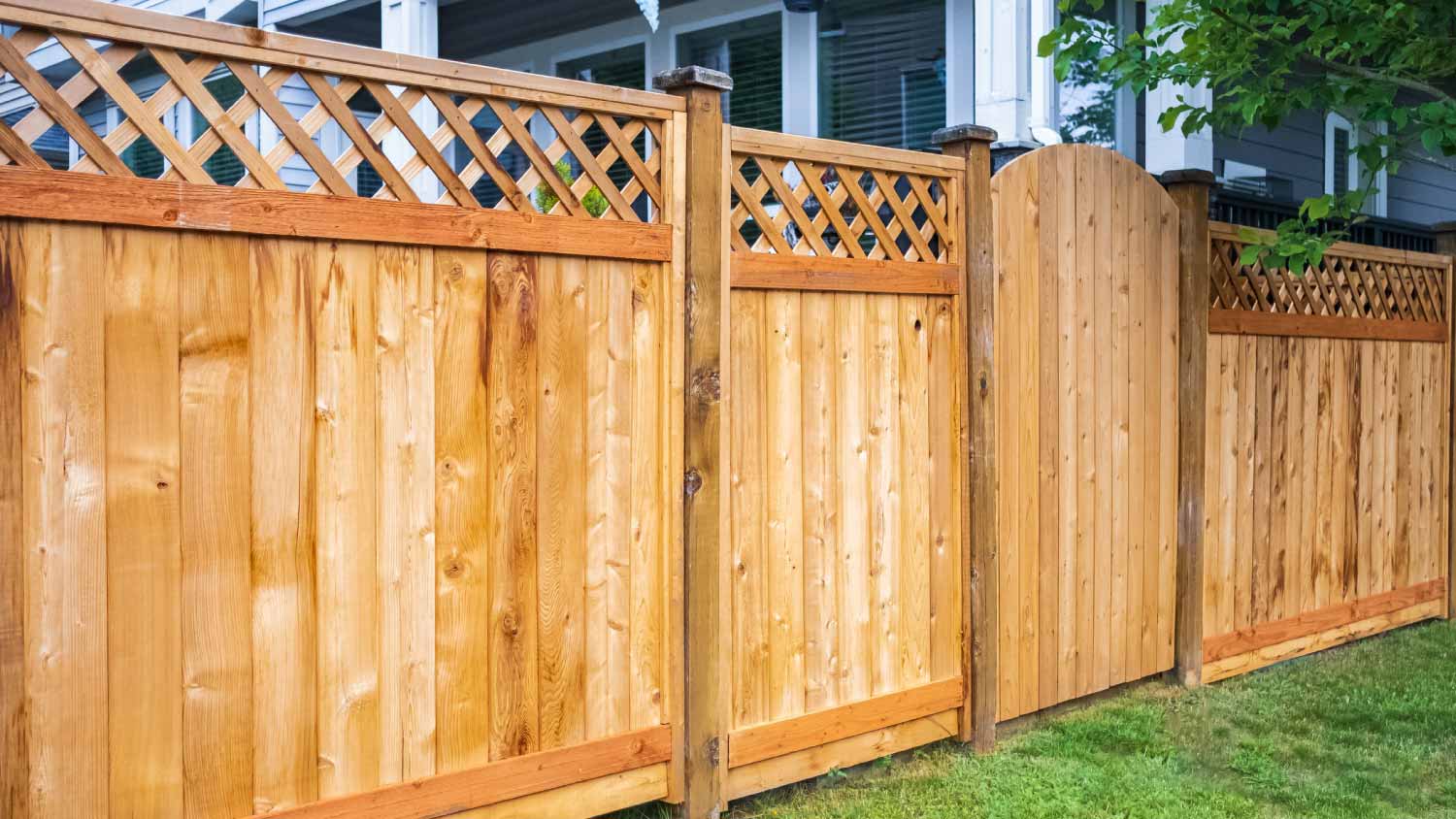 A wooden fence with green lawn