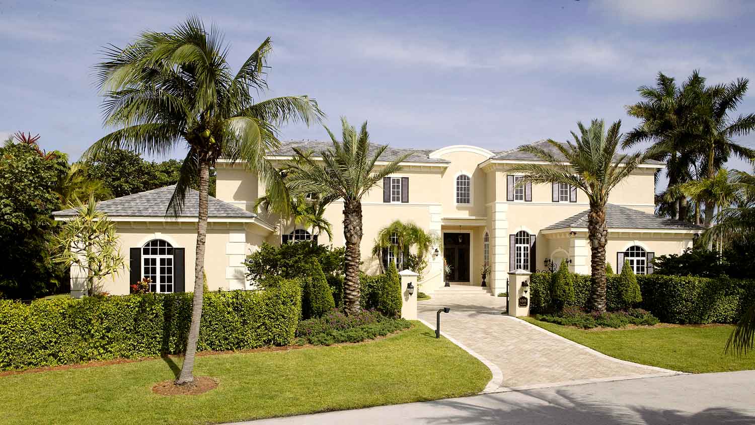 House in a tropical setting surrounded by palm trees