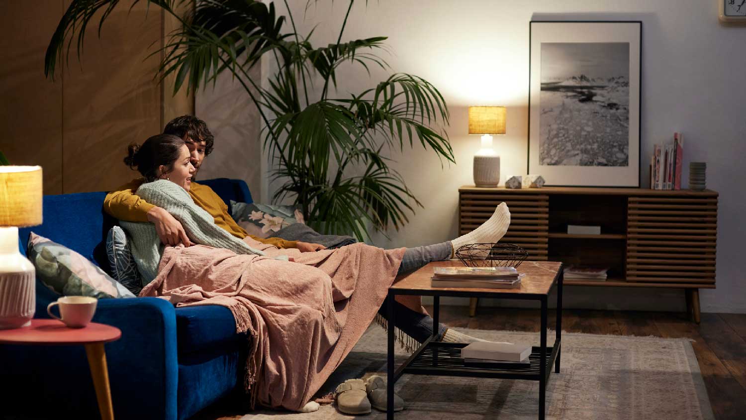 A couple relaxing in their living room with daylight bulbs