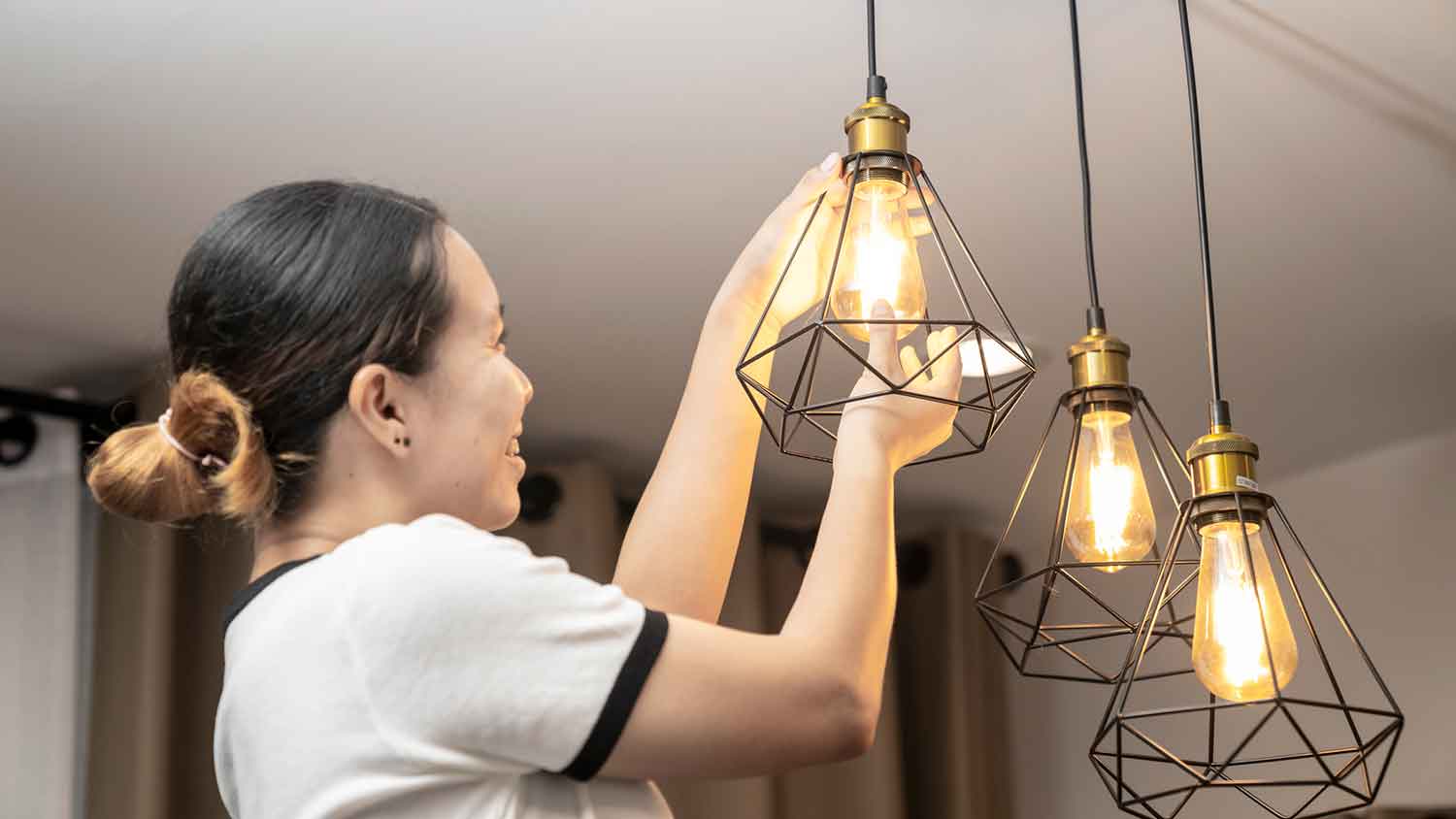 Woman replacing light bulb on a modern light fixture