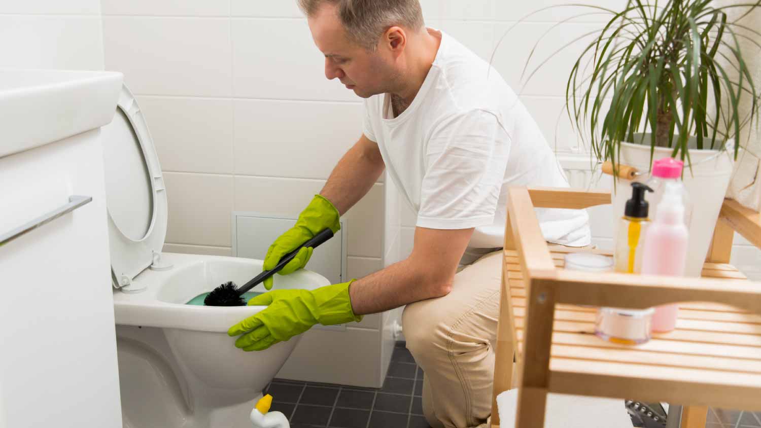 Man cleaning and washing toilet