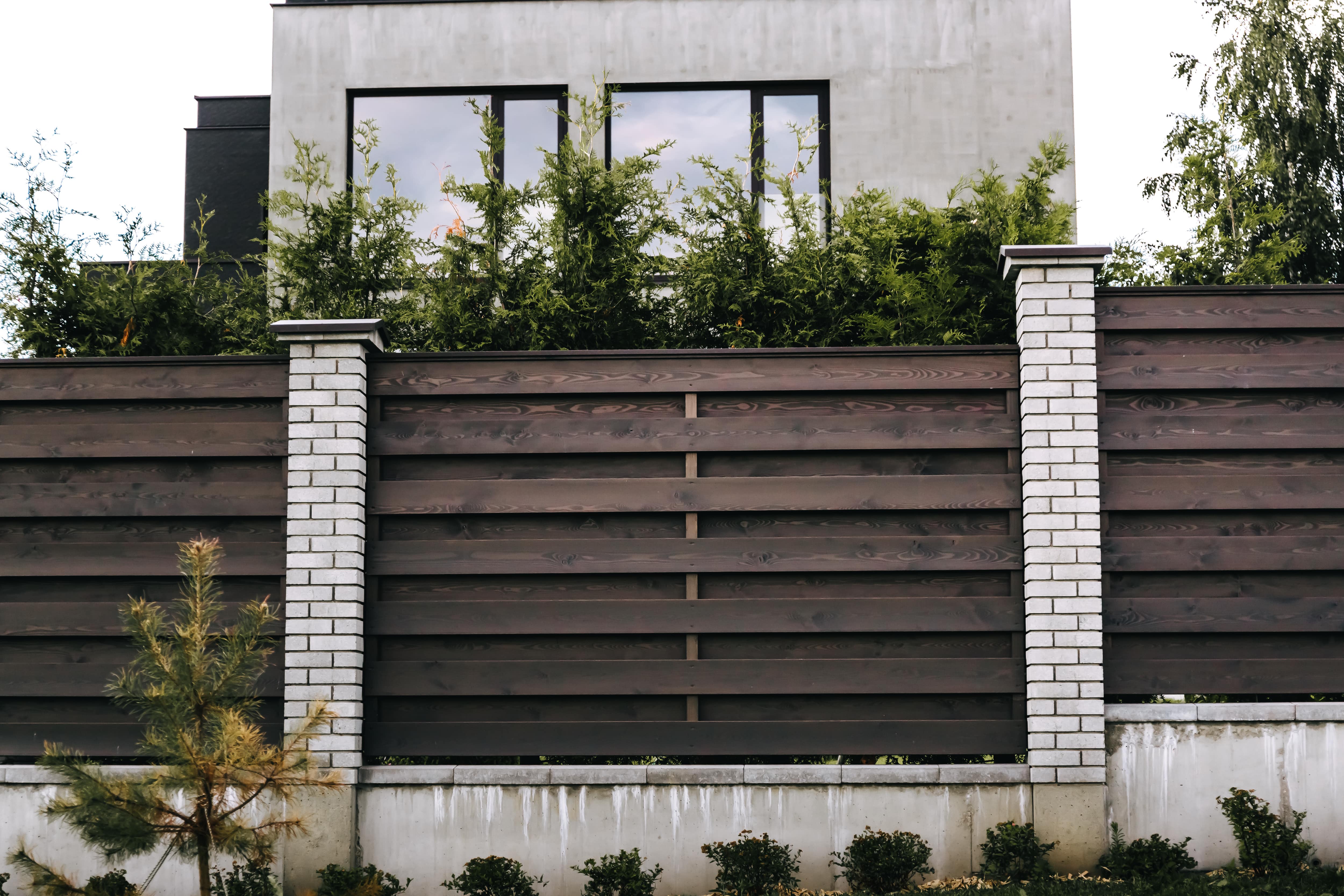 A wood and brick panel privacy fence
