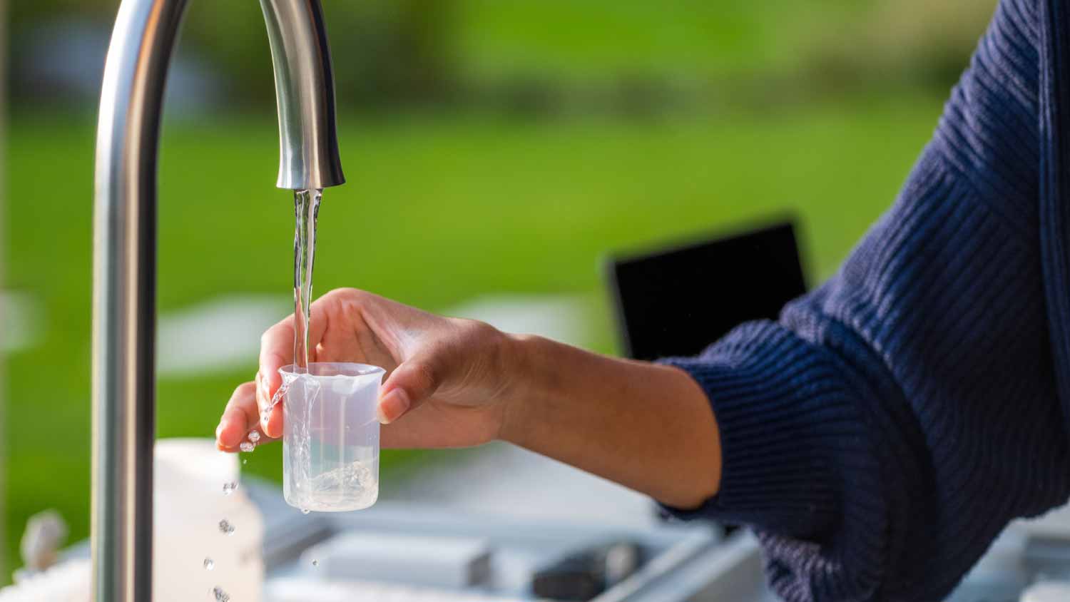 Woman collecting tap water