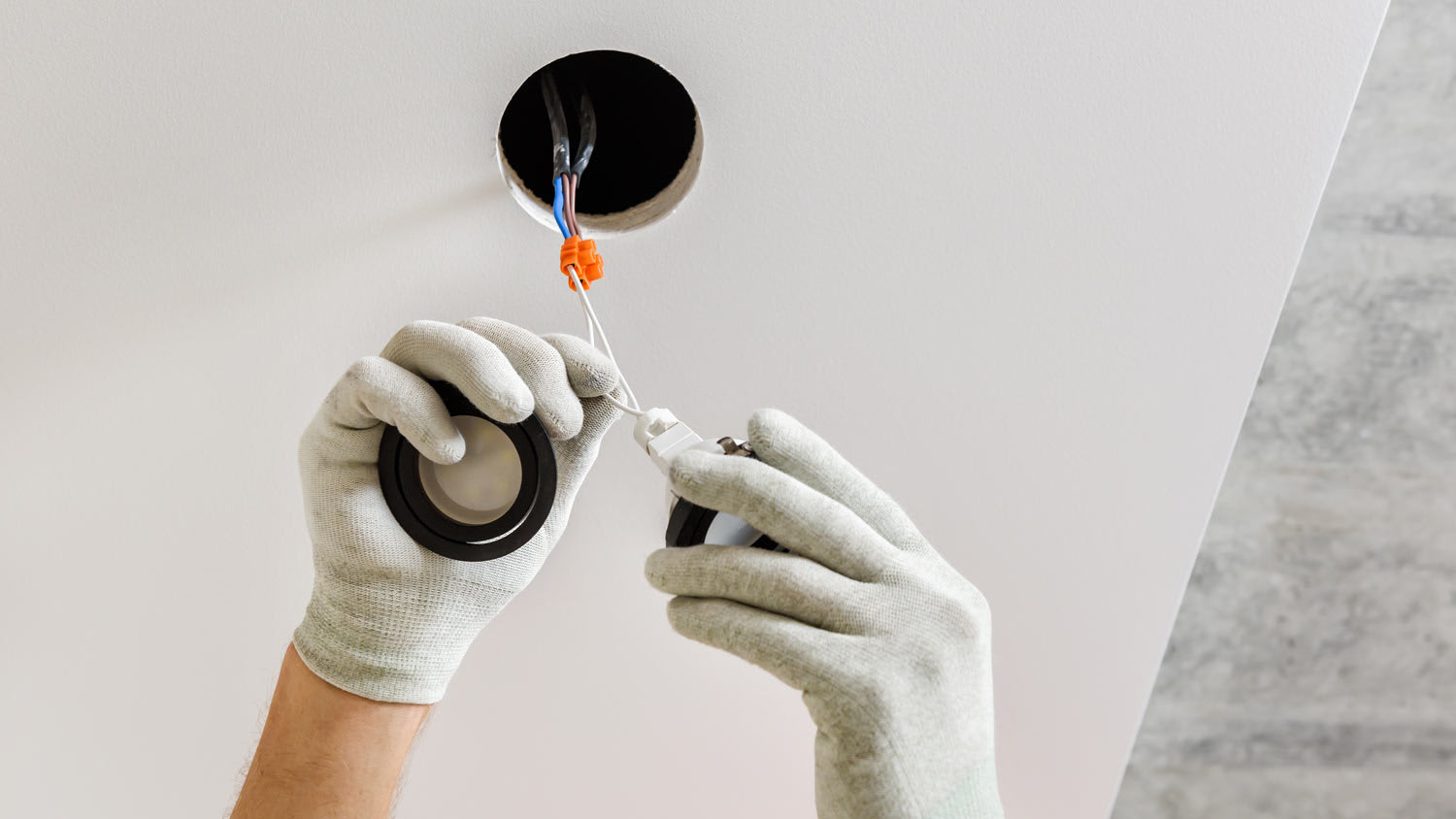 man changing recessed light