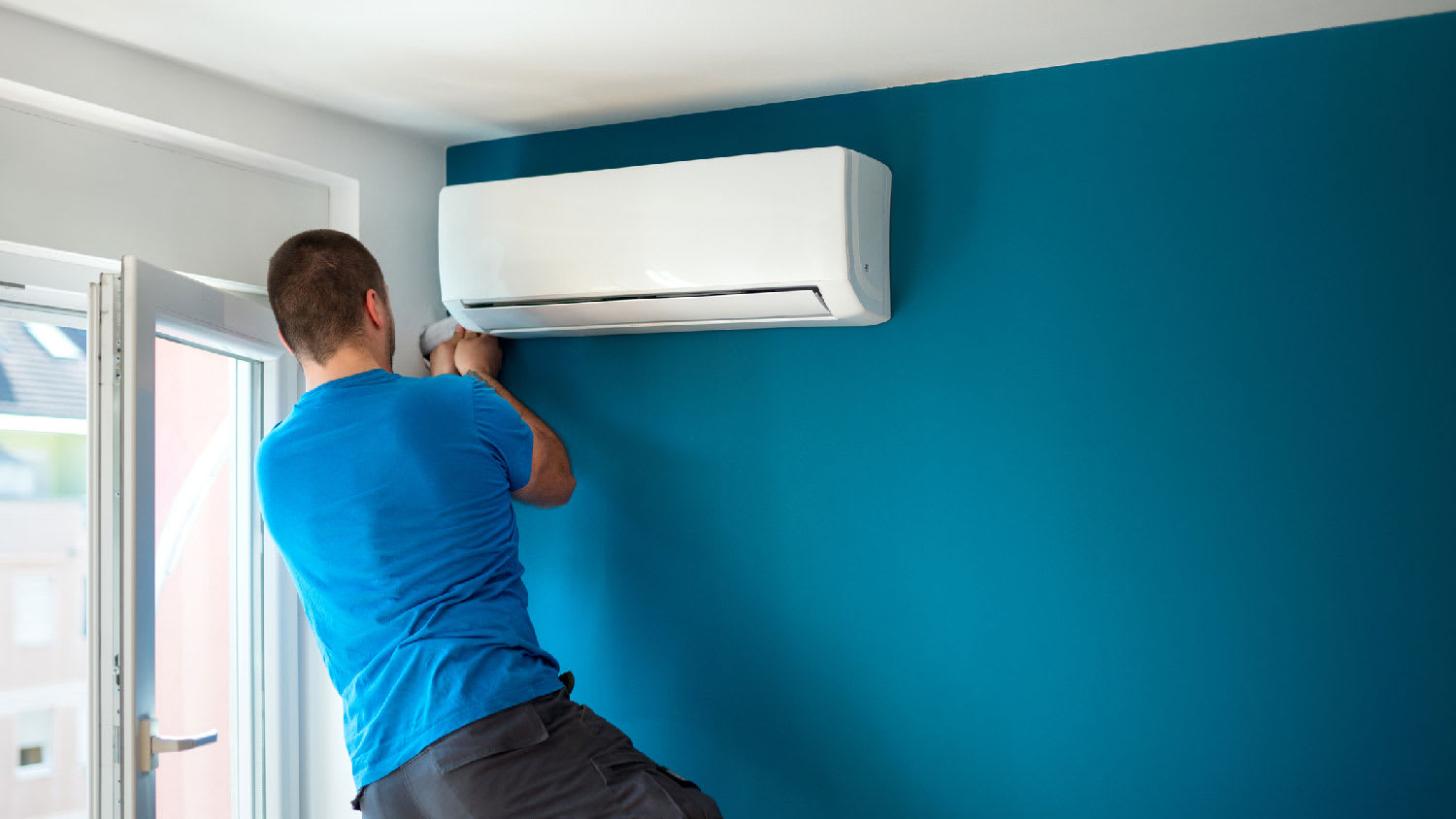 A person installing a mini-split system