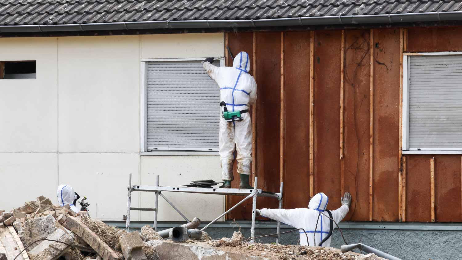Professionals in protective suits removing asbestos