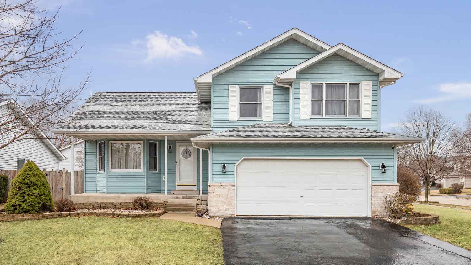A light blue house with a white garage