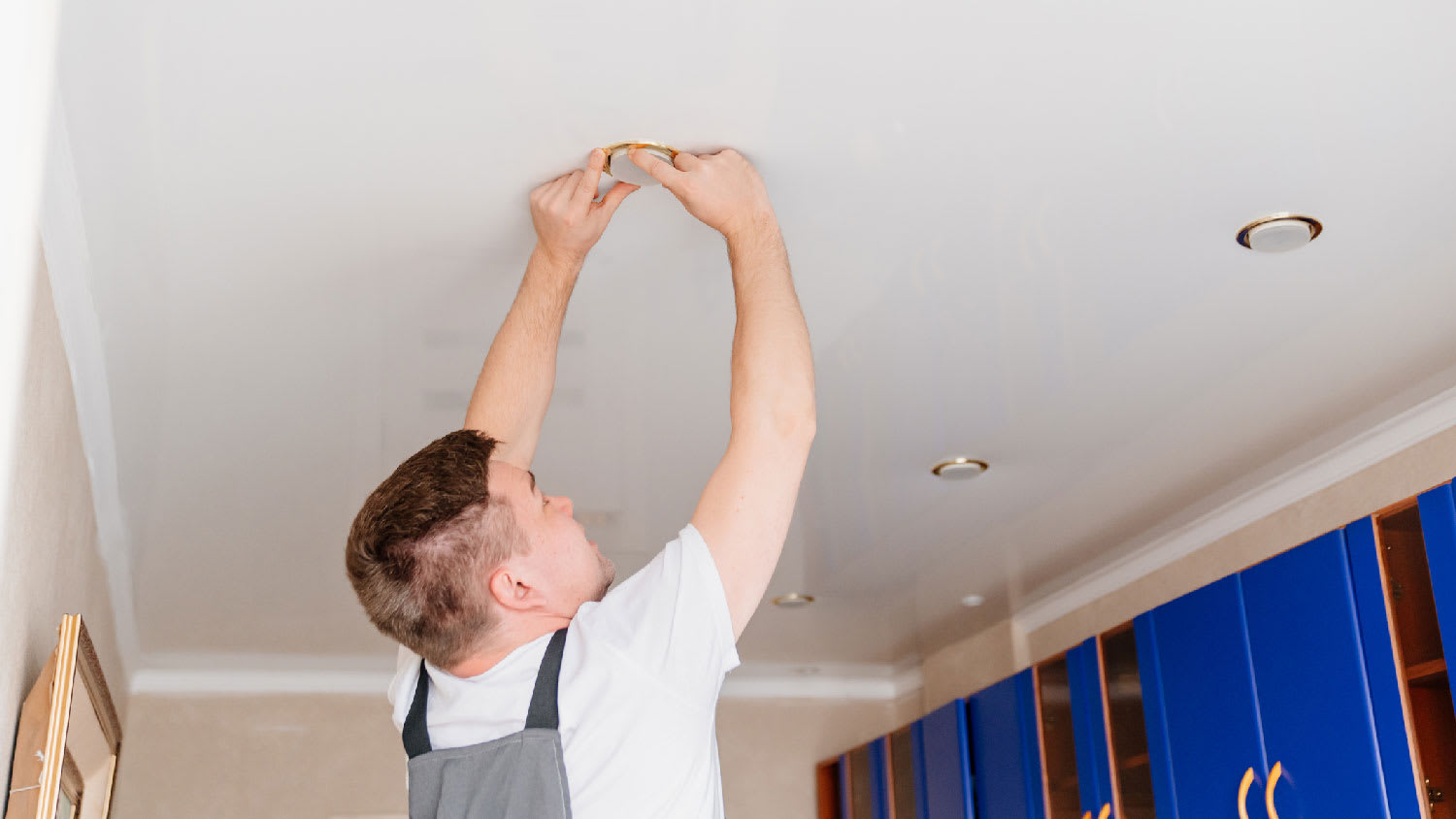 A man changing a bulb in a canless lighting