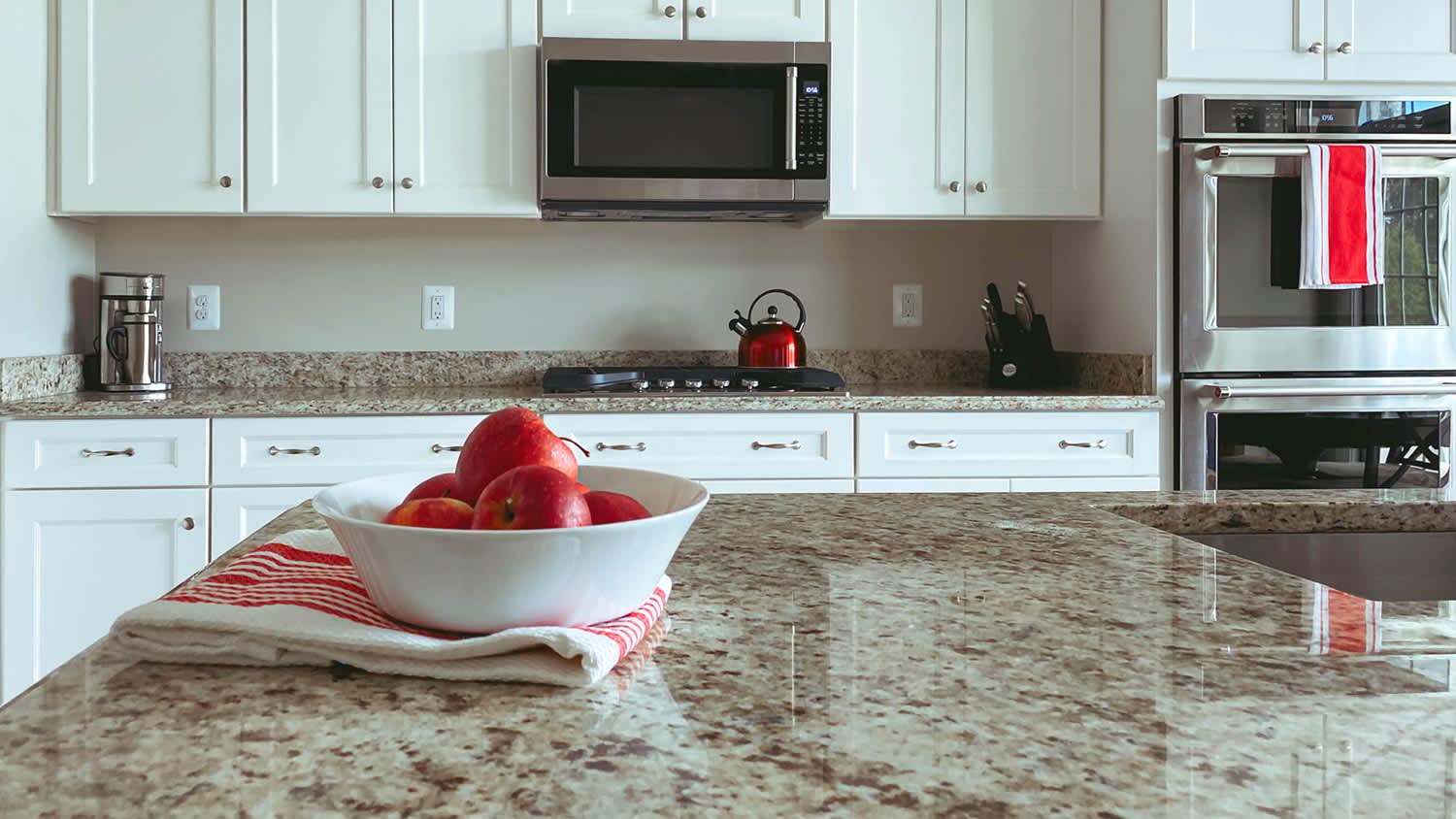 Bowl of apples sitting on granite countertops