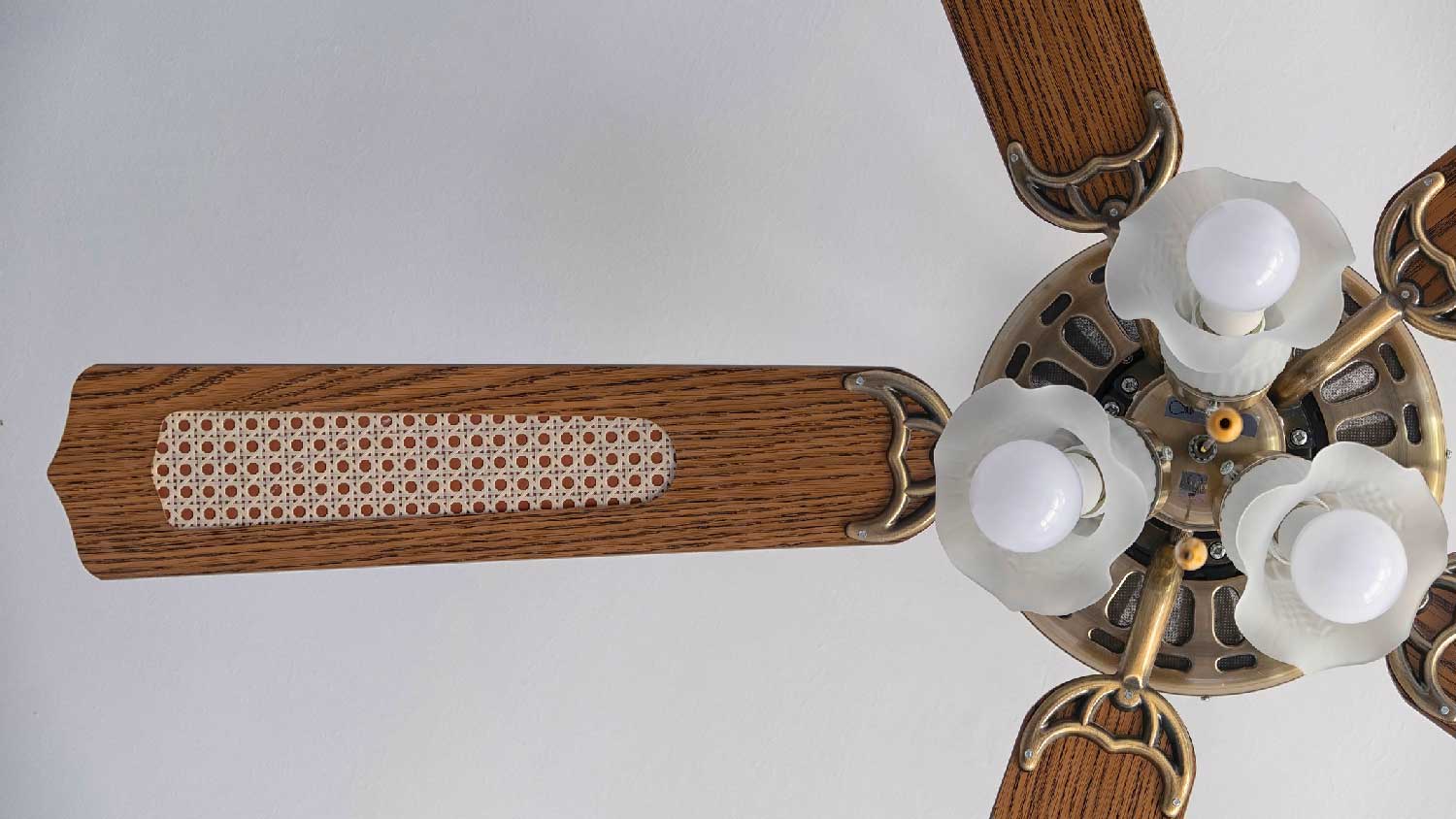 A ceiling fan with three light bulbs