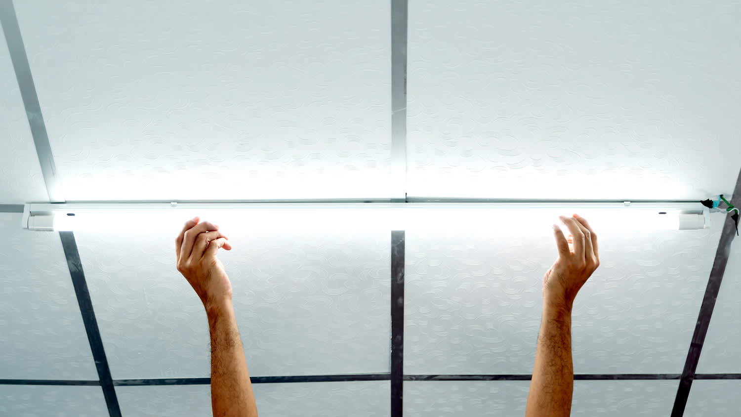 Installing a long LED light bulb on the ceiling