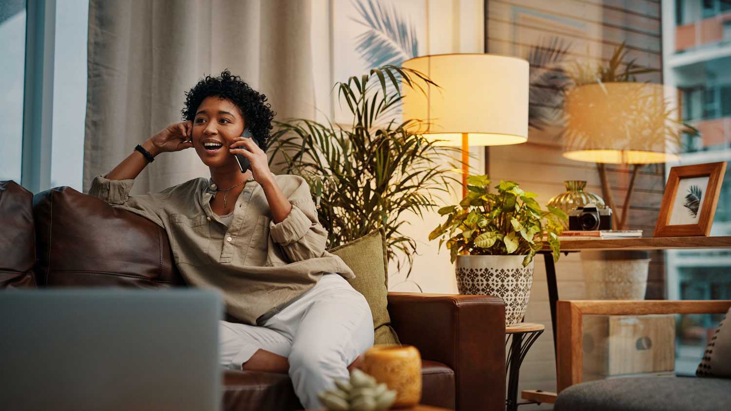 young woman talking on her cellphone while sitting at home