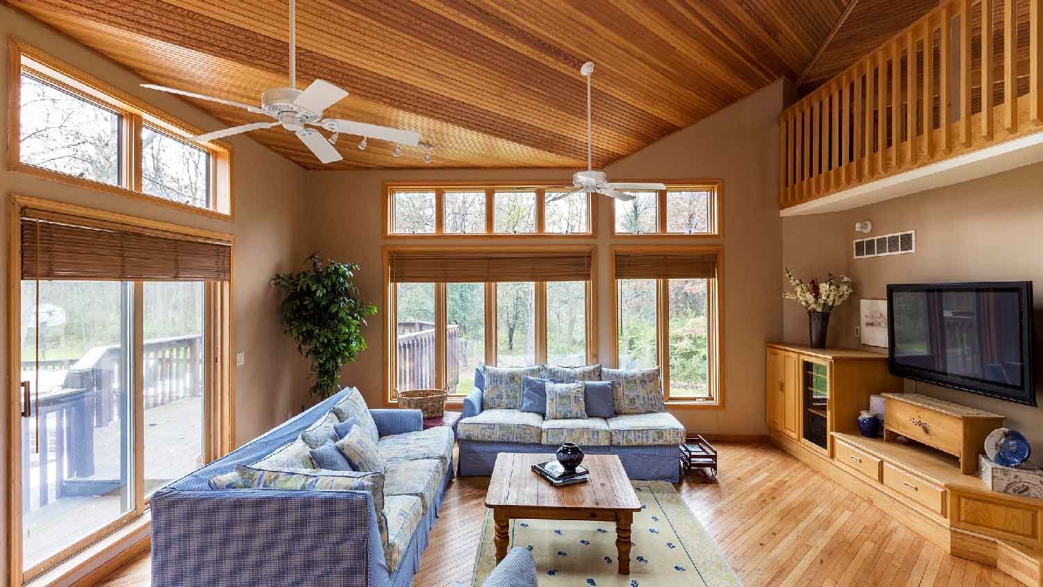 A living room with hardwood floors and two ceiling fans