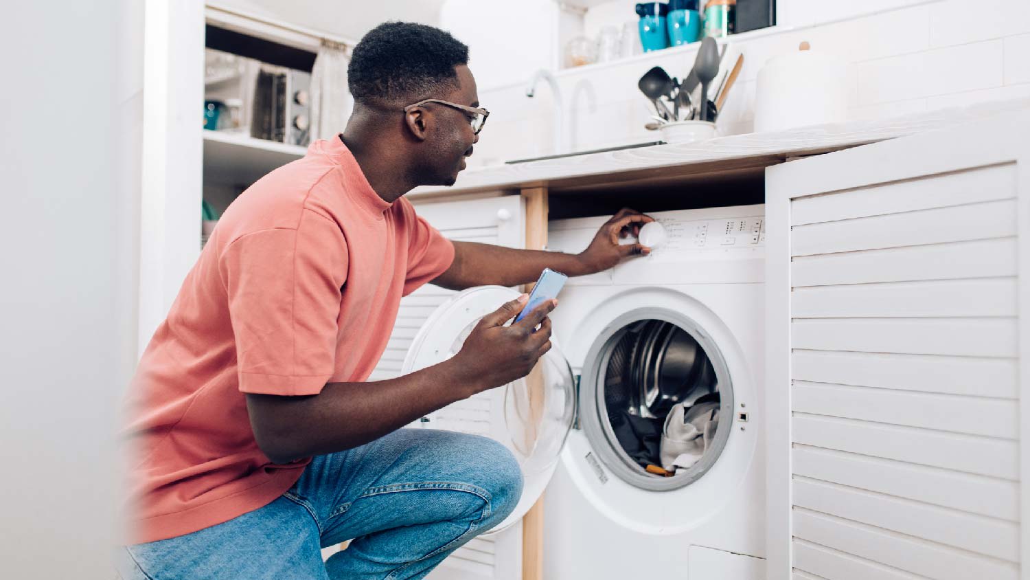 A young ma starting a cycle in the washing machine