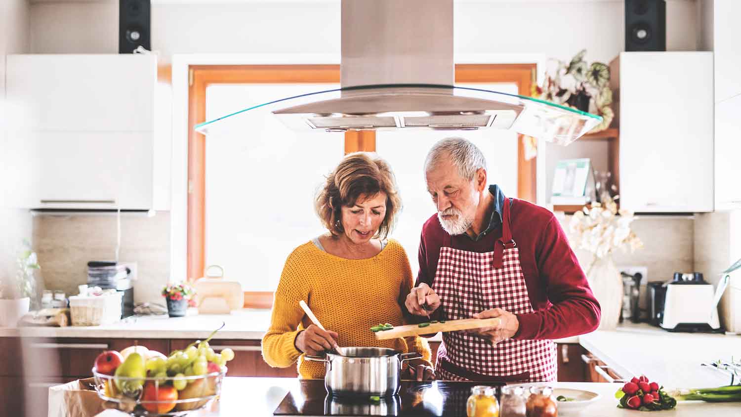 Senior couple cooking dinner together
