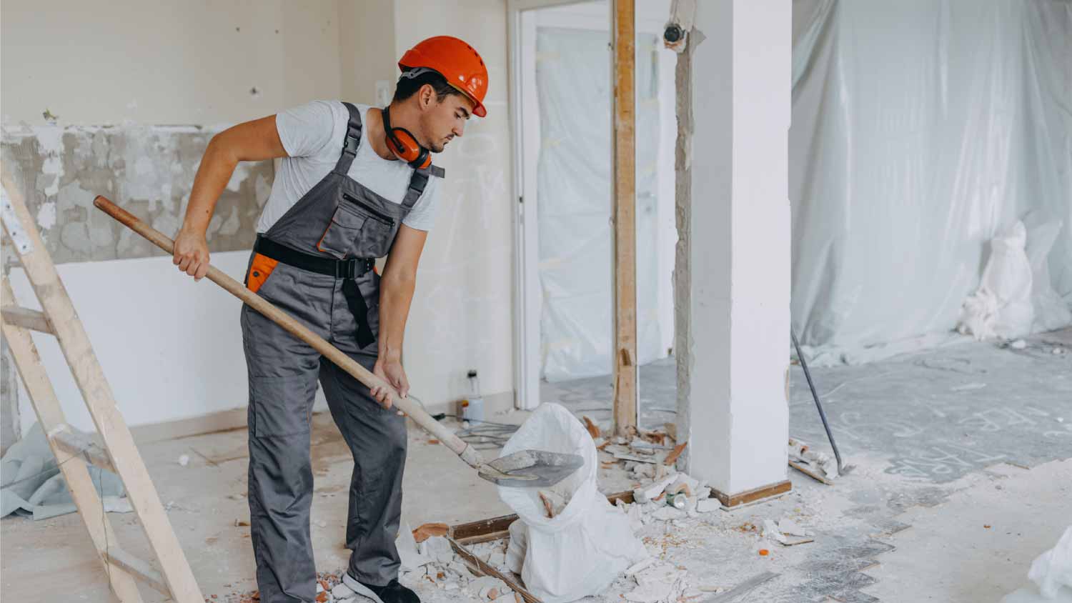 Worker using shovel to tear down wall