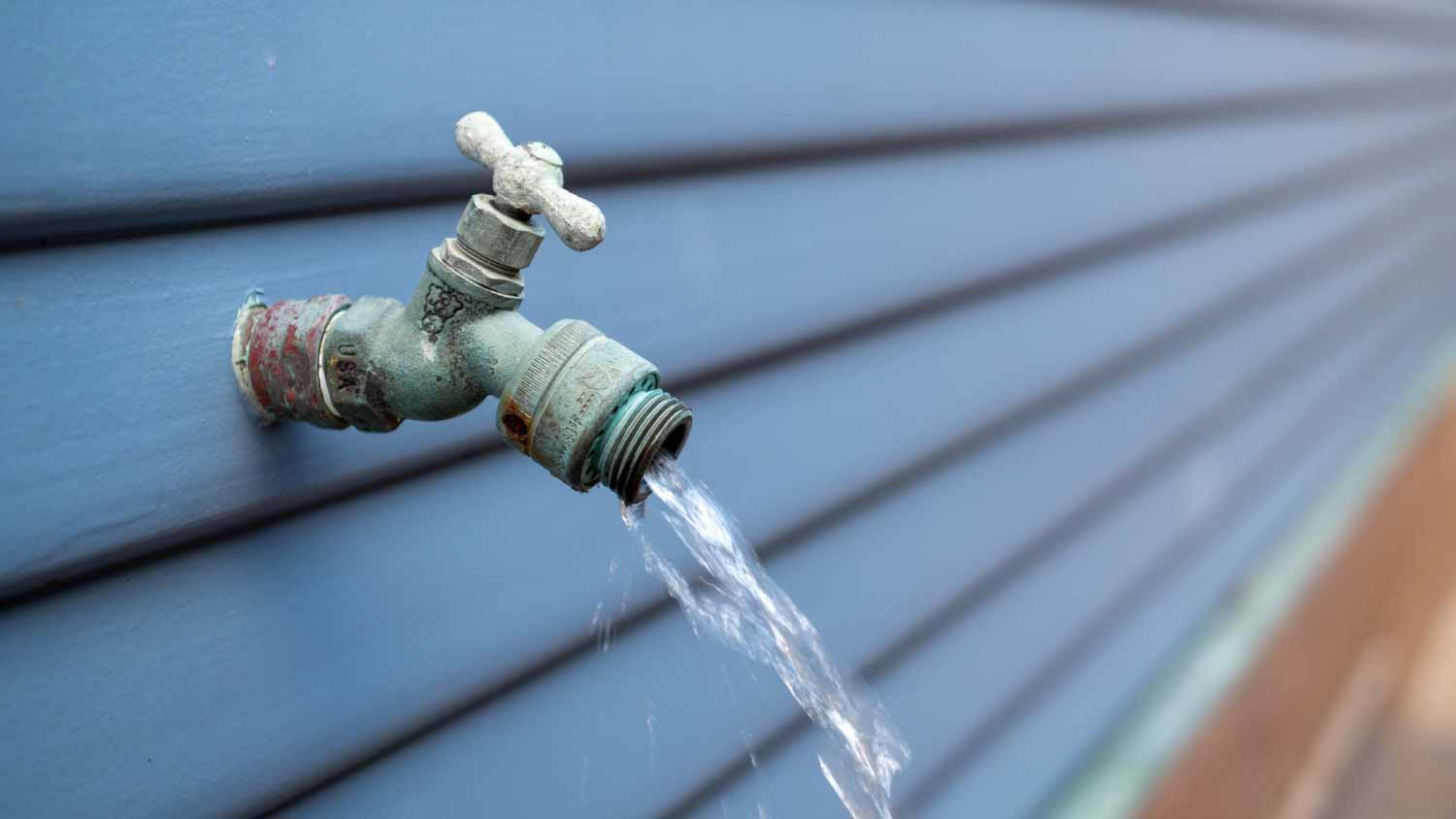 Water streaming out of outdoor faucet