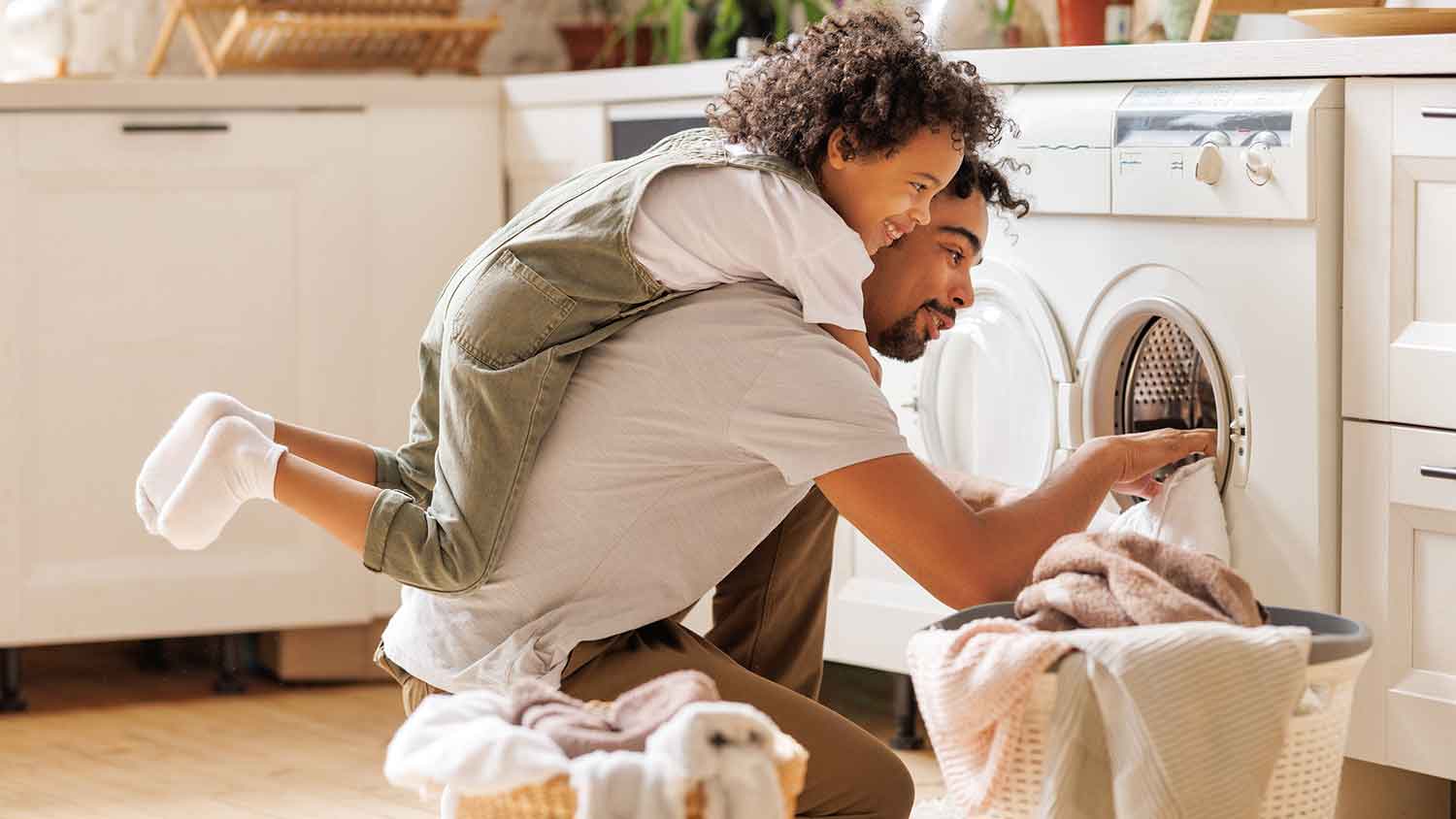 Father and young son doing laundry at home