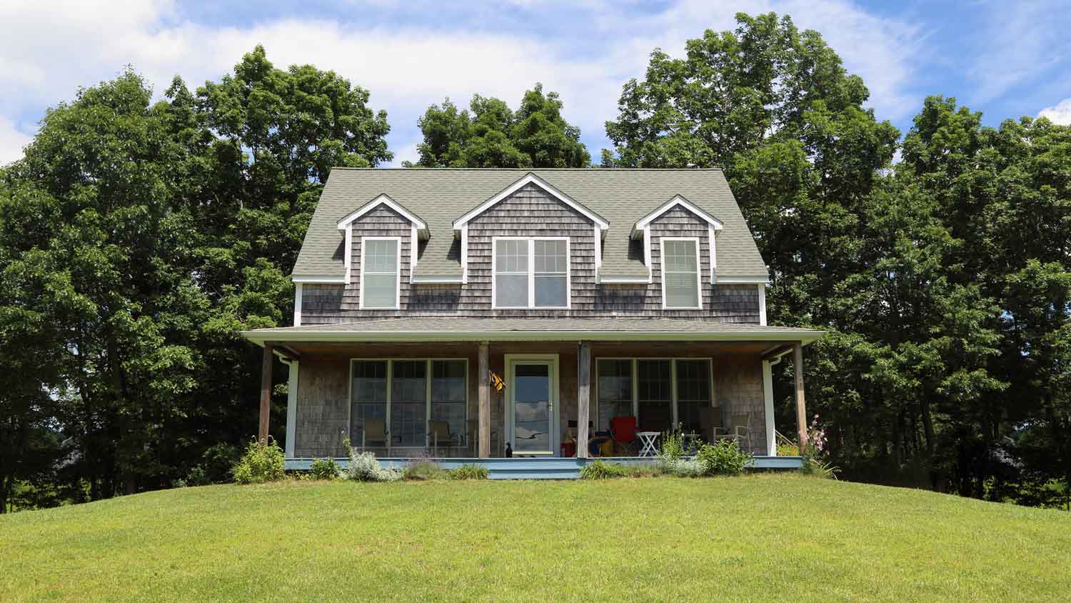 A house built on elevated ground with a great front lawn