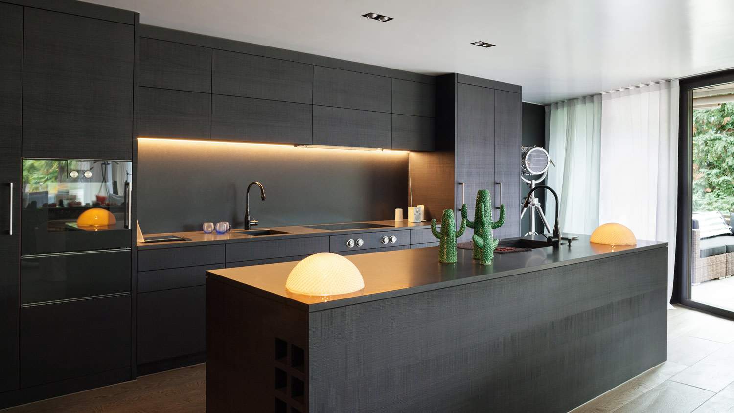 The interior of a modern kitchen with black cabinets