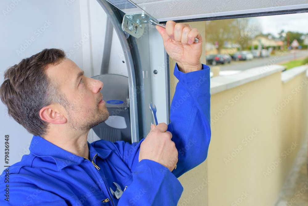 A man fixing garage door extension spring