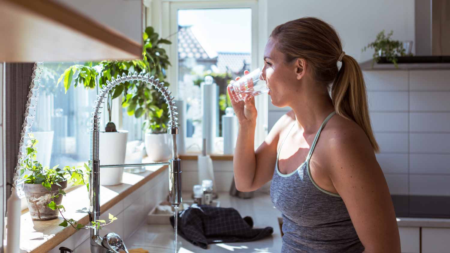 Woman drinking water at kitchen