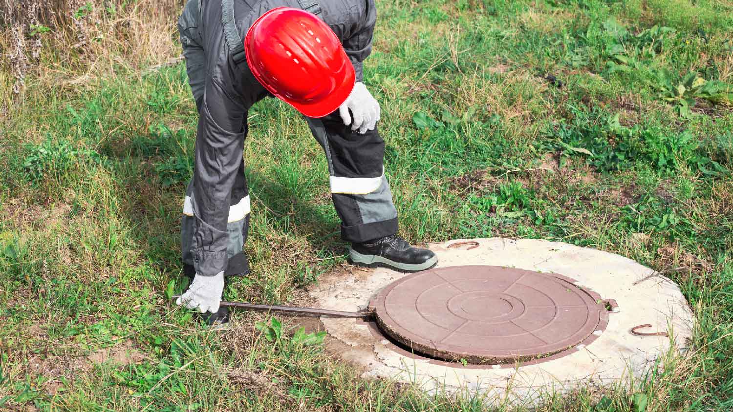 A man opening a cesspool