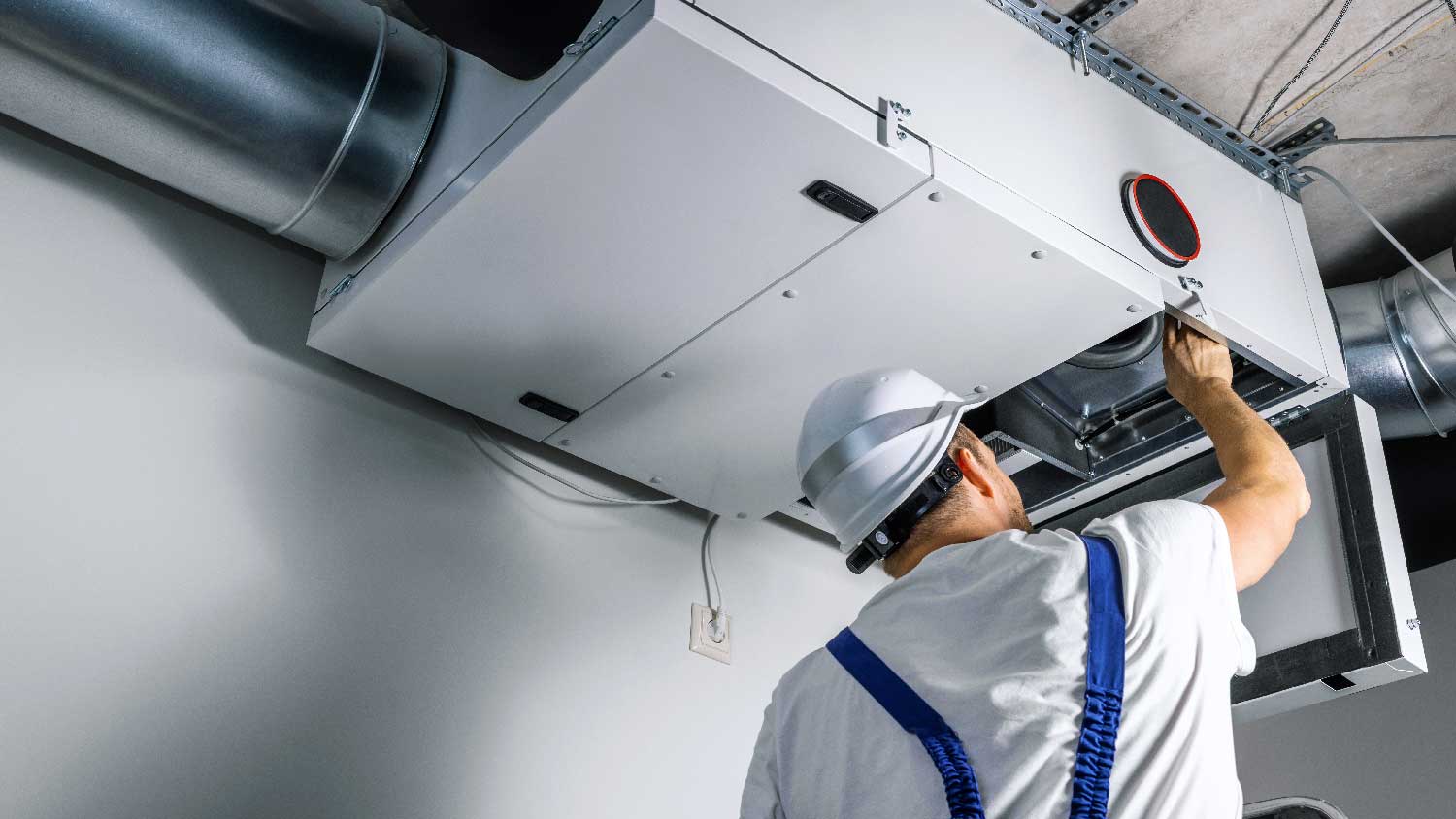 A man cleaning an air duct