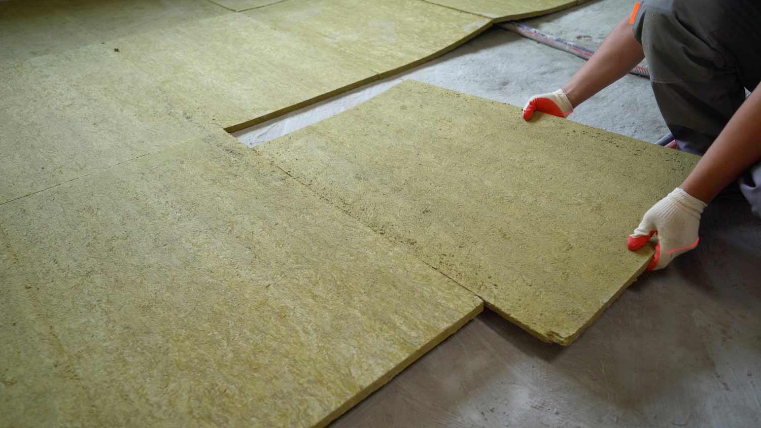 builder laying down glass wool for insulation