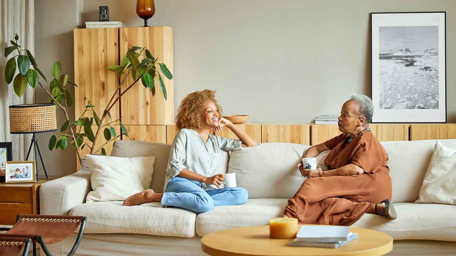 Mother and daughter sitting on the sofa enjoying coffee