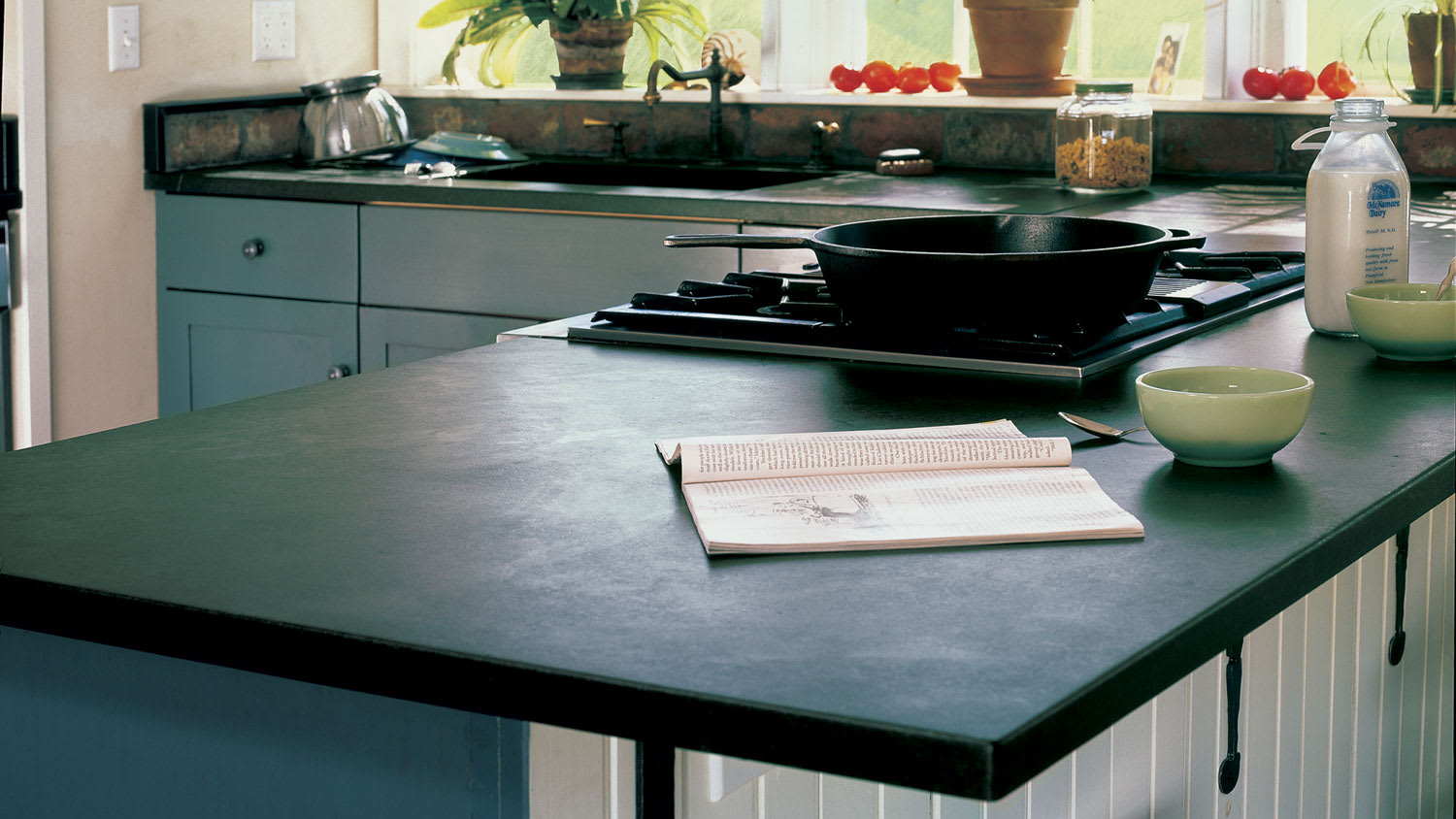 A soapstone countertop with a frypan on the stove