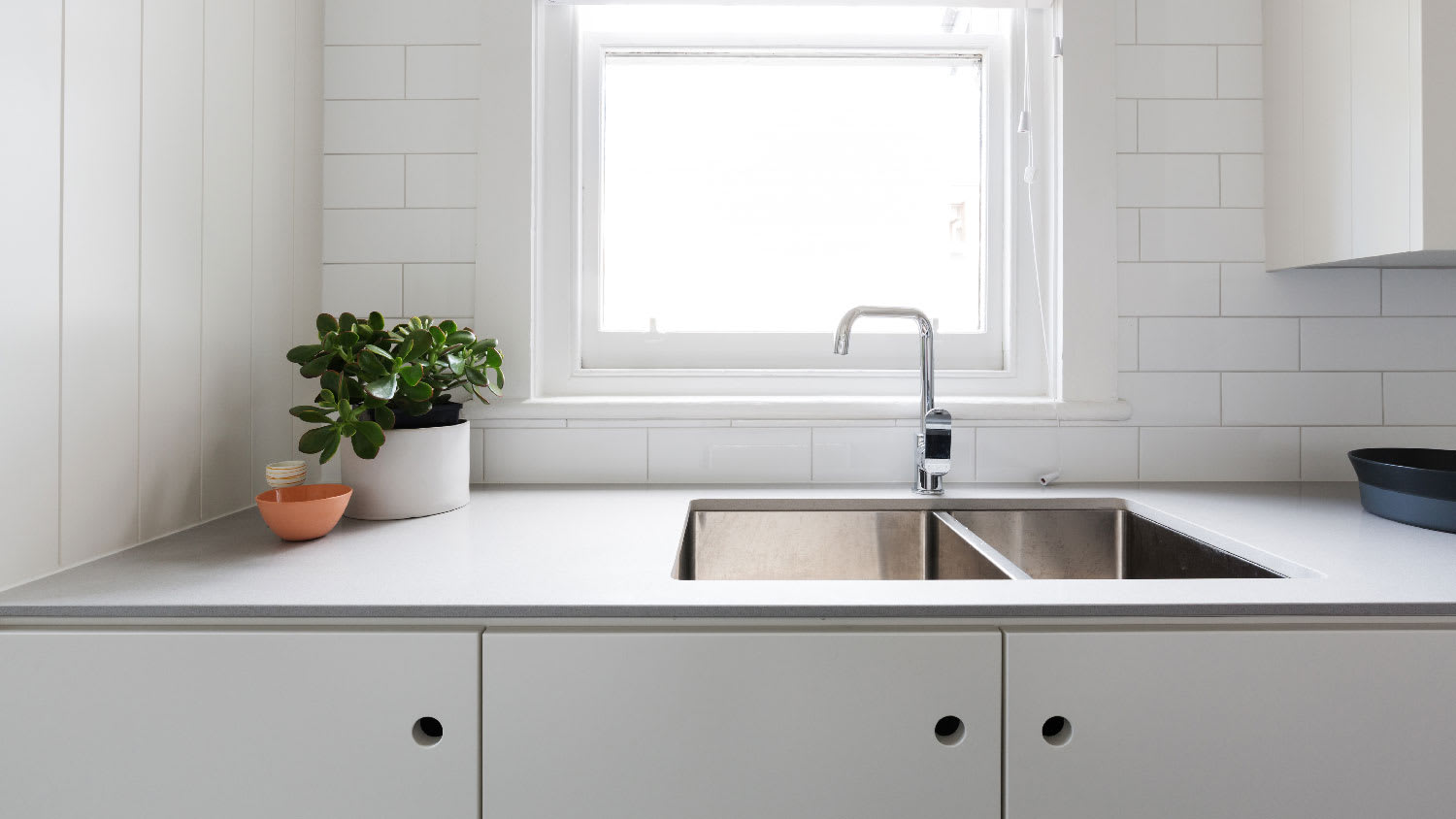 A contemporary kitchen with a laminate countertop and subway tiles