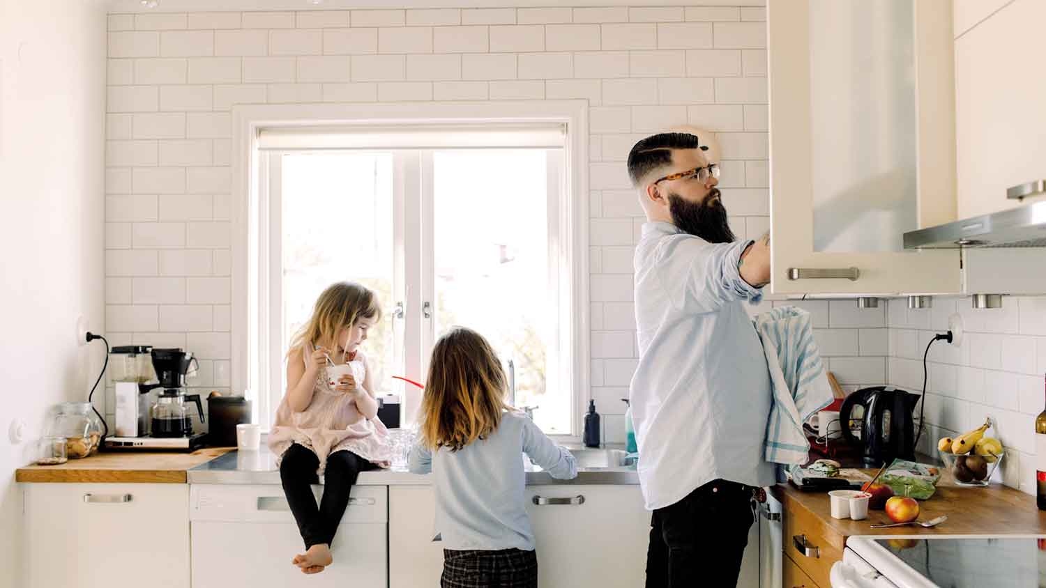 Daughter helping father doing chores in the kitchen