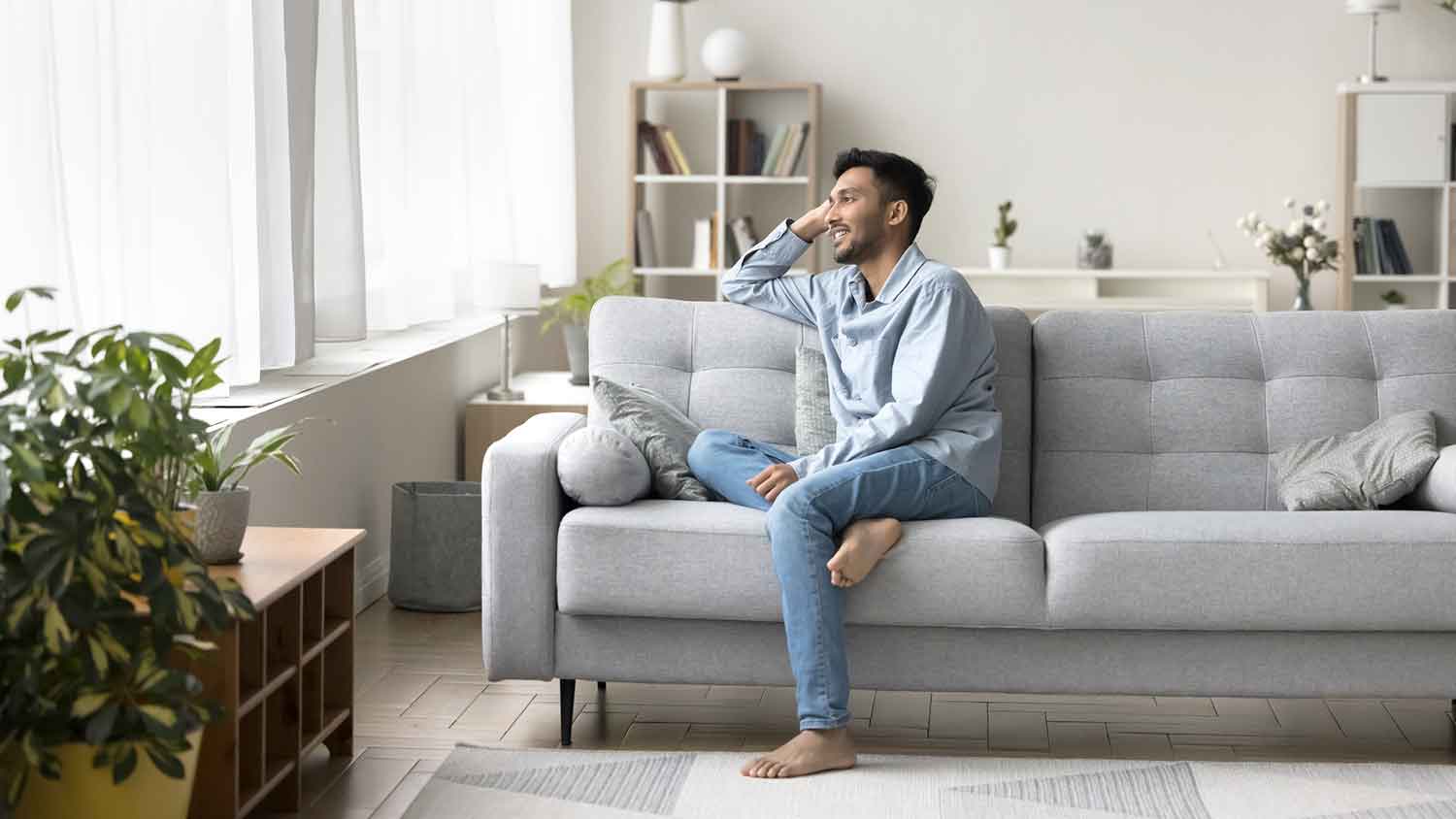 Young man sitting on the couch relaxing after work