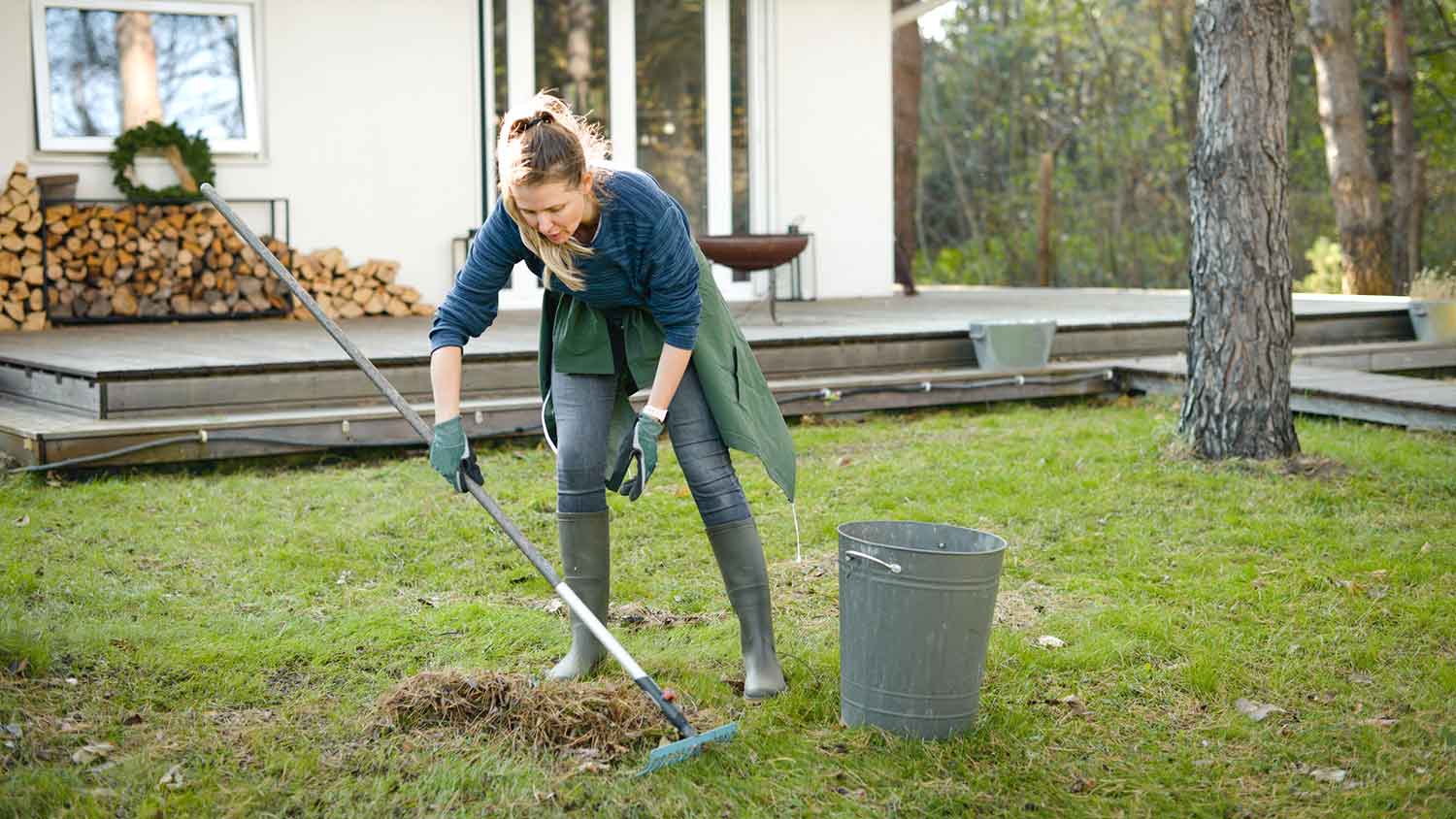 Woman using rake to clean the backyard