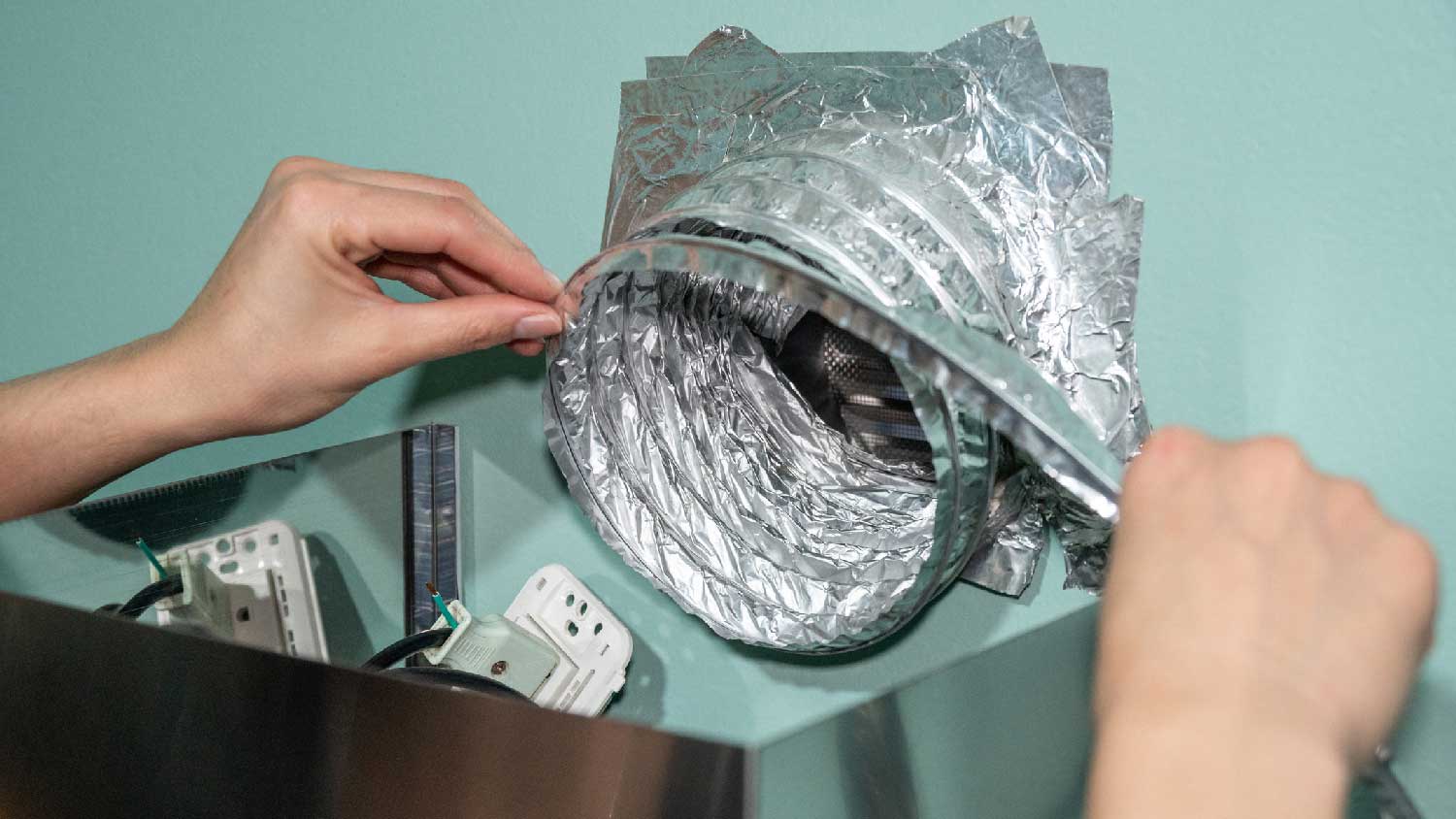 A woman inspecting an air duct