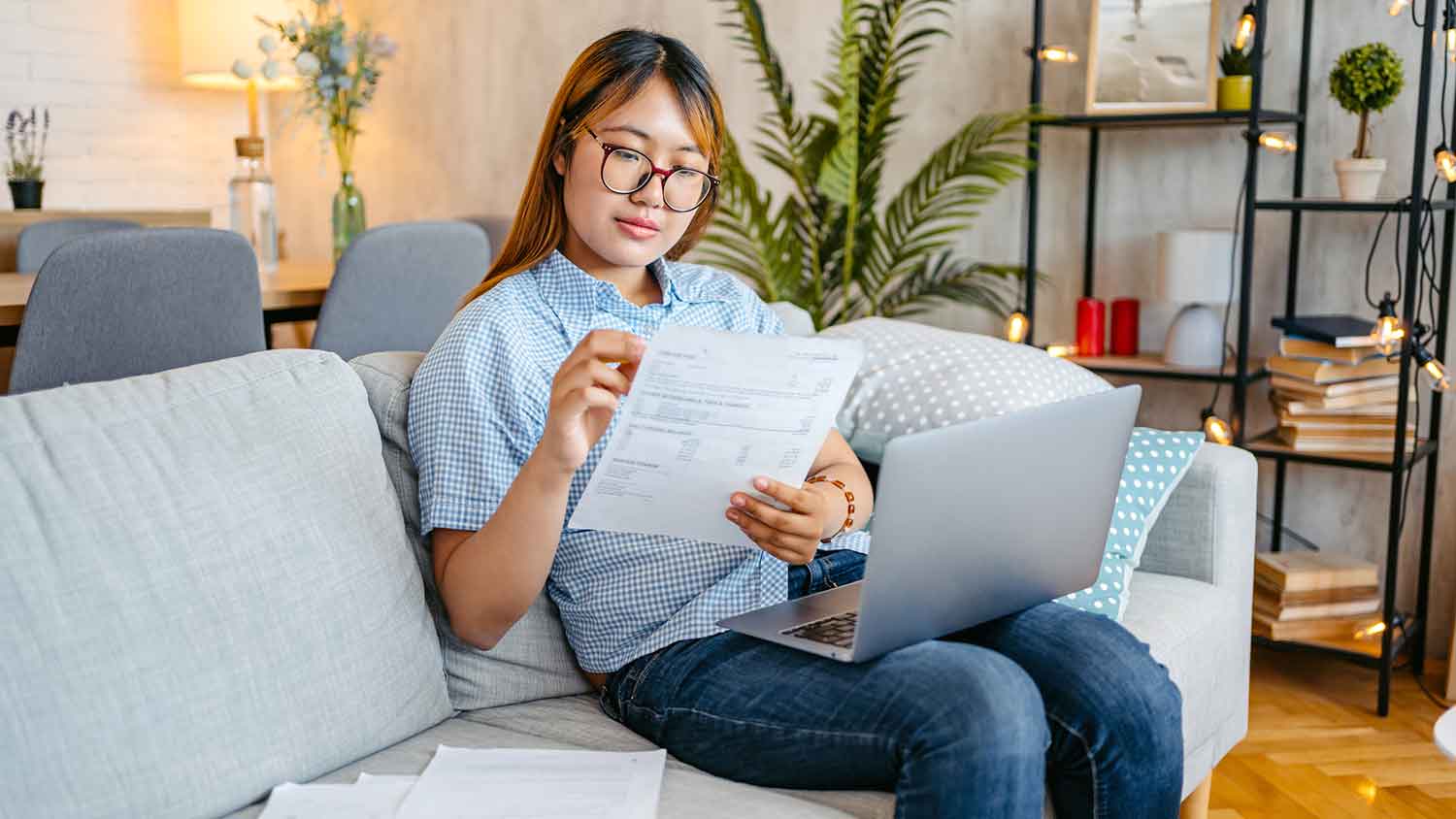 Woman sitting on the couch checking utility bill