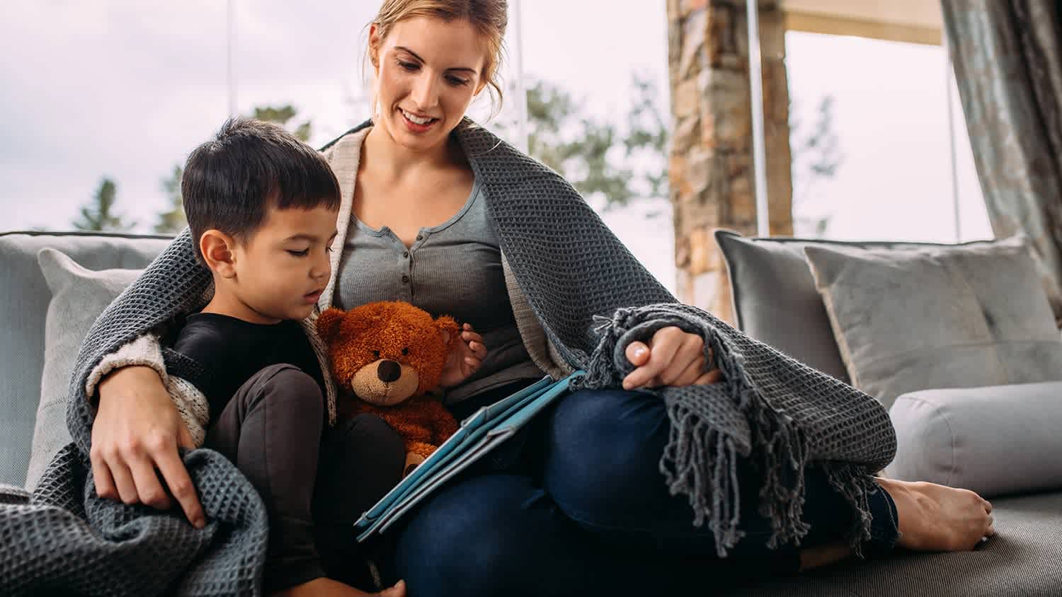Mom and child read under blanket