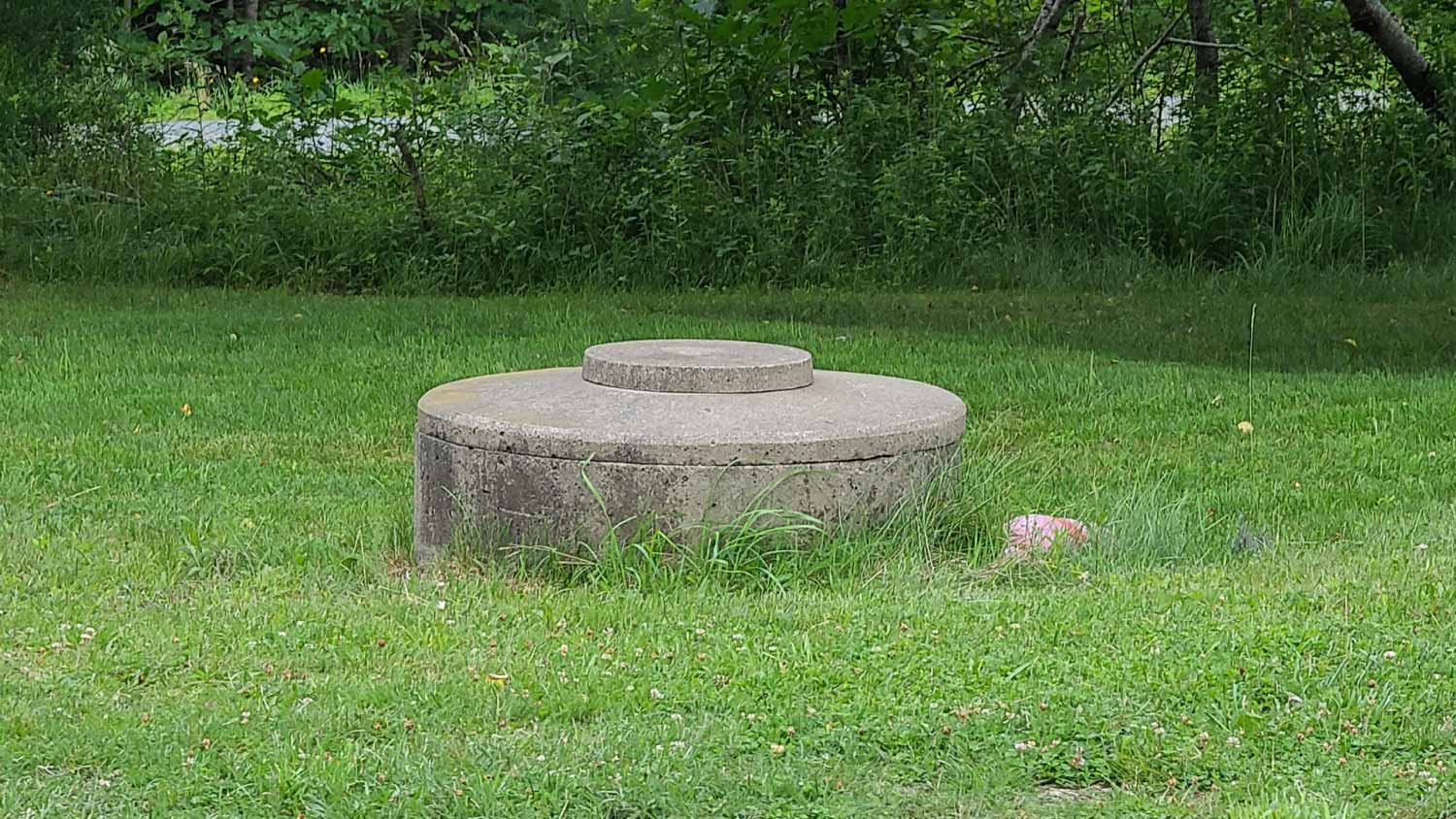 A dug well sticking out of a lawn