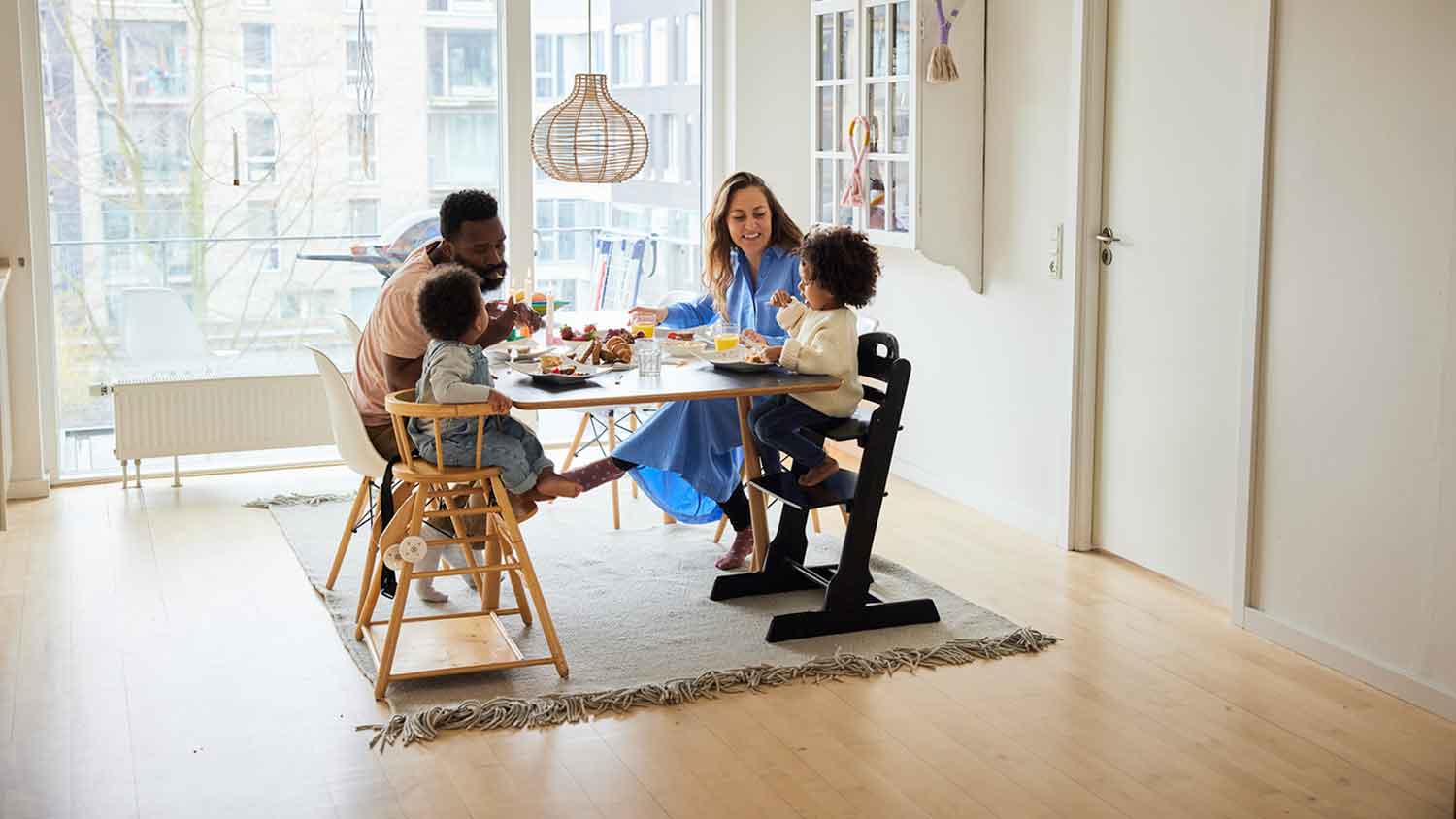 Parents and little children eating breakfast at the table