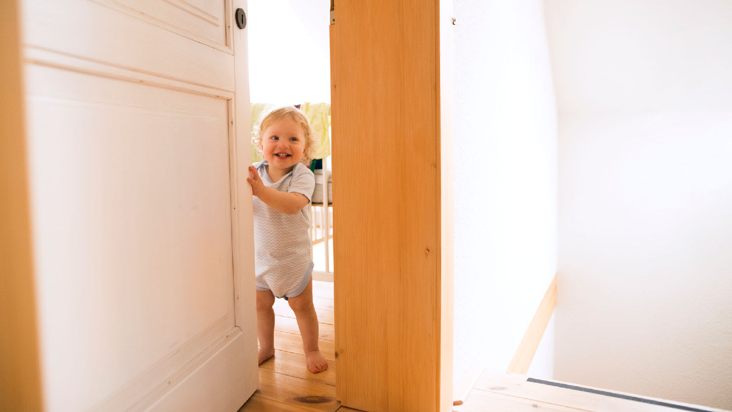 A happy baby in front of an open door