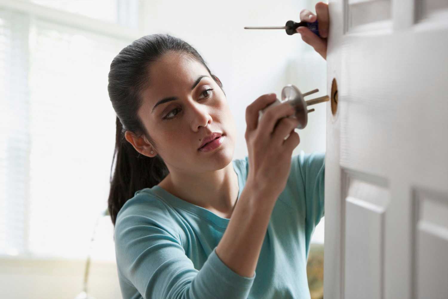 A woman replaces door knob